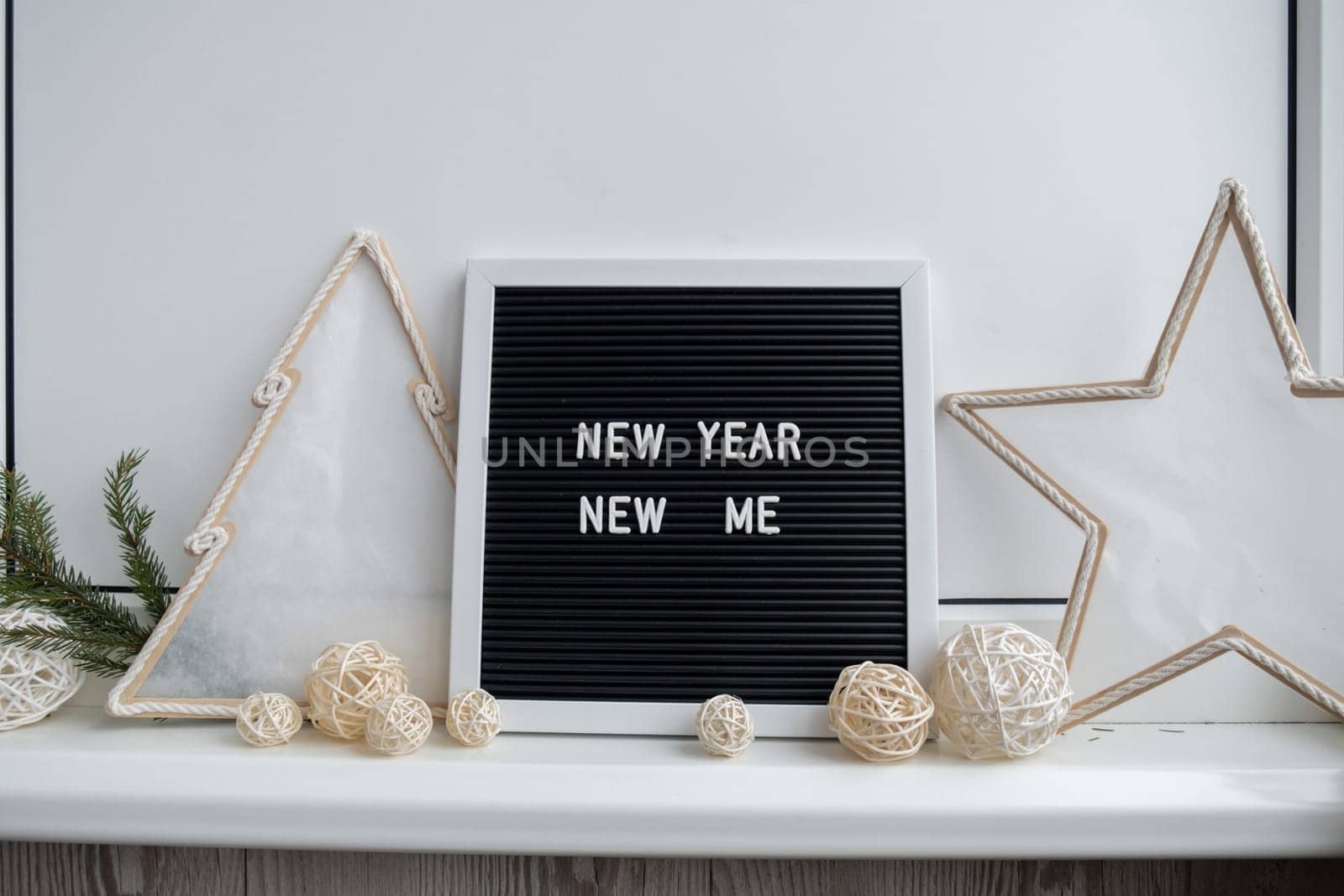 NEW YEAR NEW ME text on black letter board with cozy minimalistic handmade Christmas decor. New year aims resolutions. Low key festive Planning and setting goals by anna_stasiia