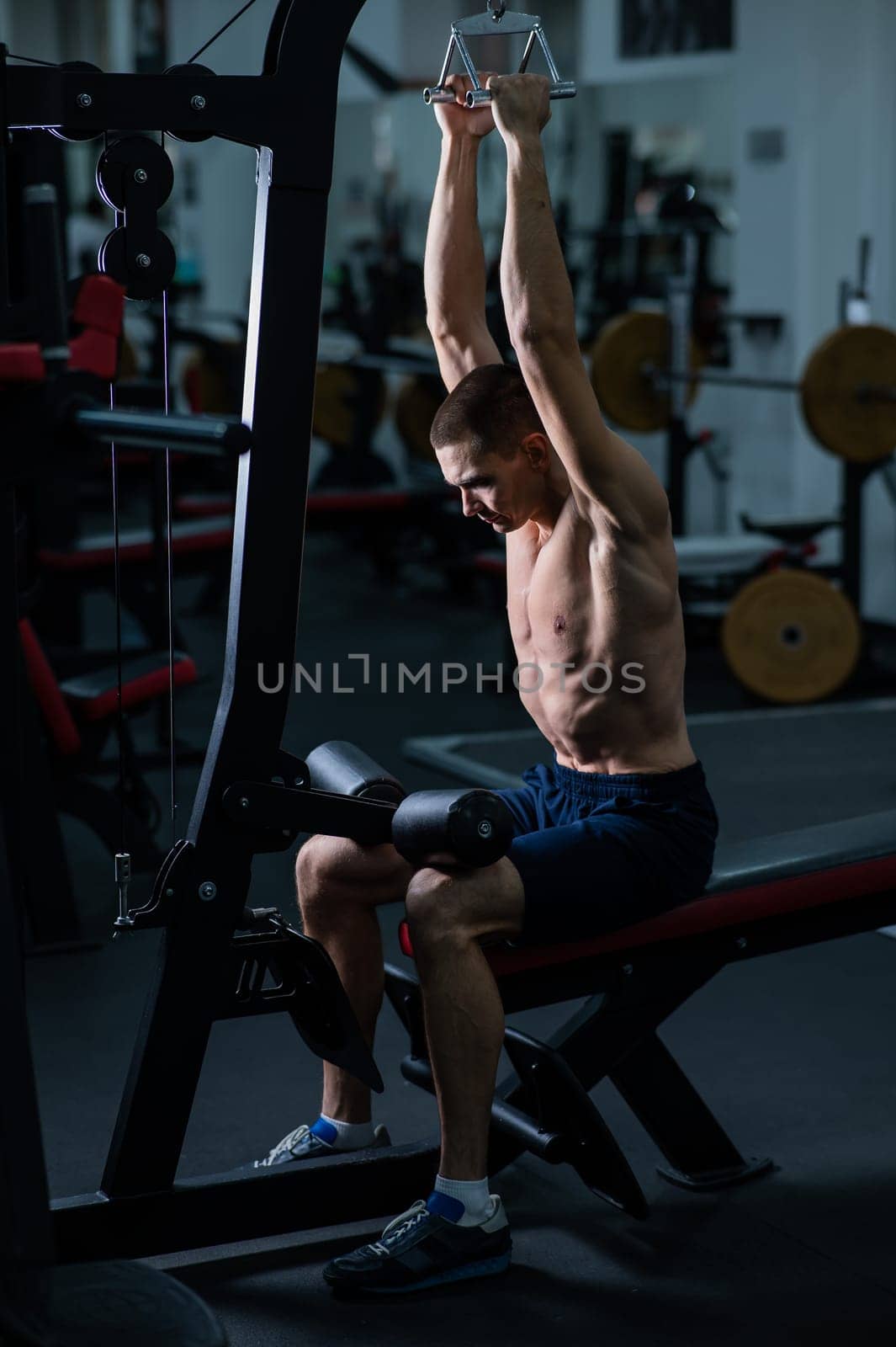A man does a chest pulldown in the gym