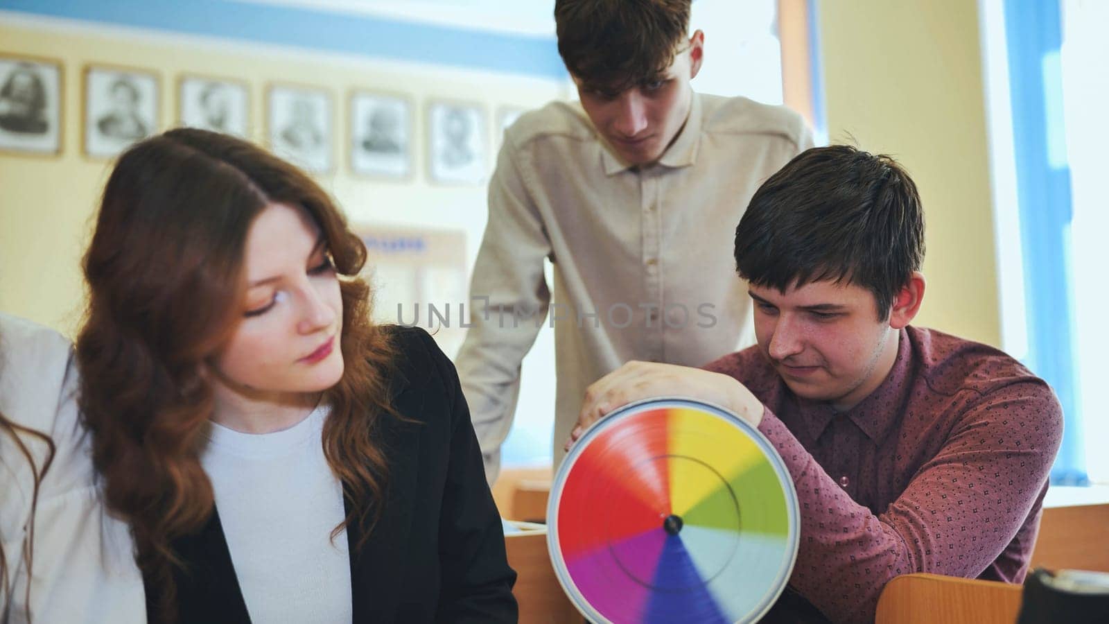 Students in physics class spin Newton's colorful wheel.