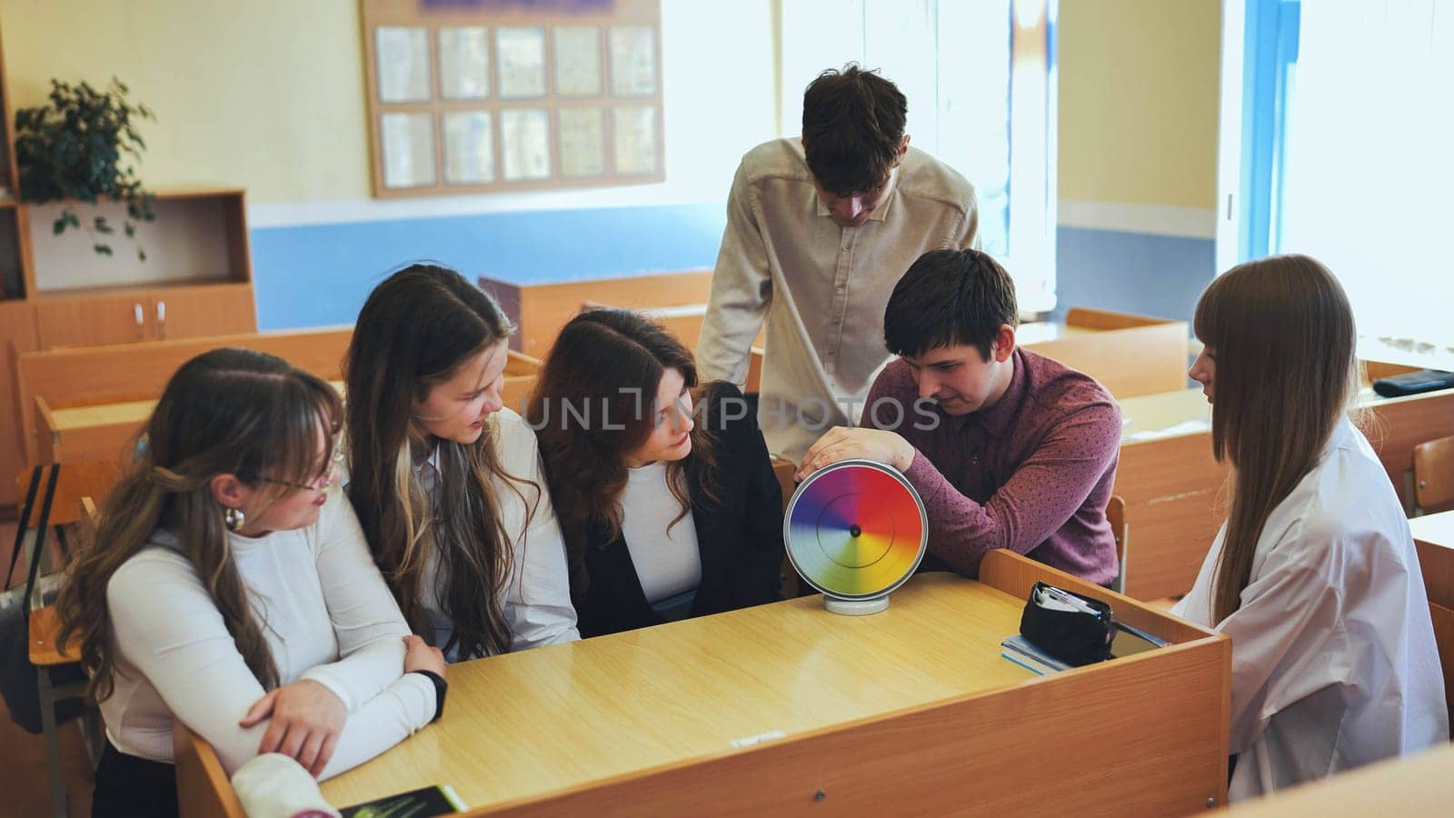 Students in physics class spin Newton's multicolored disk. by DovidPro