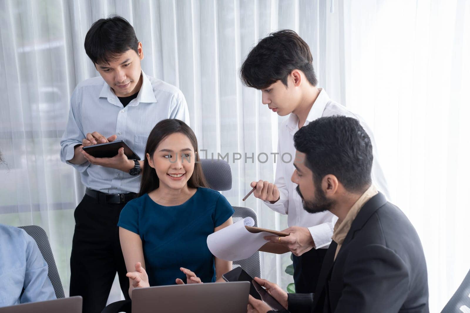 Professional Asian employee work together as team in corporate office, discussing business plans and data to achieve success on desk with laptop. Modern office worker teamwork concept. Concord