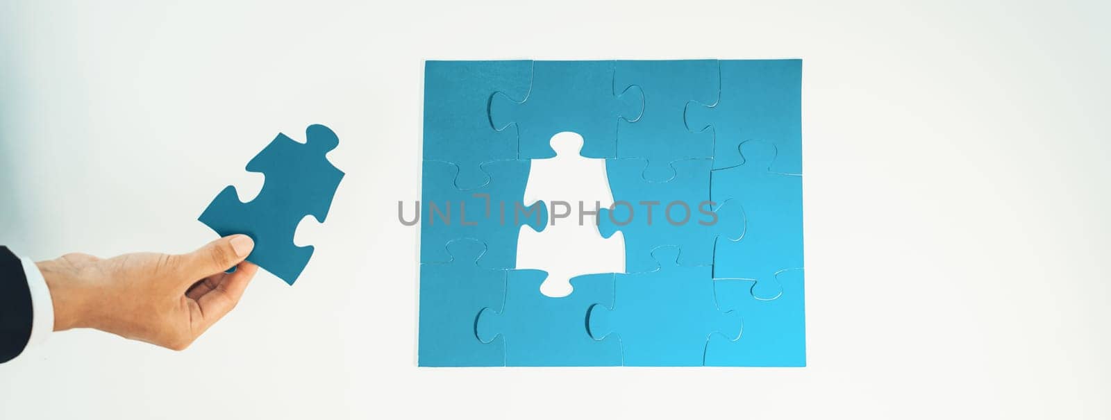 Panorama banner of business team assembling jigsaw puzzle over table symbolize business partnership and collective teamwork for HR recruitment and job seeker background. Shrewd