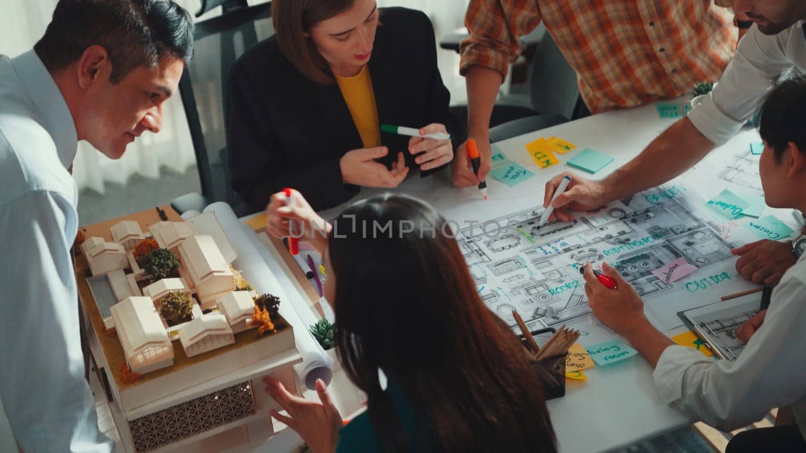 Group of diverse team planning strategy while sitting at table with project plan. Top aerial view of smart business people working together to brainstorm and design house construction. Alimentation.