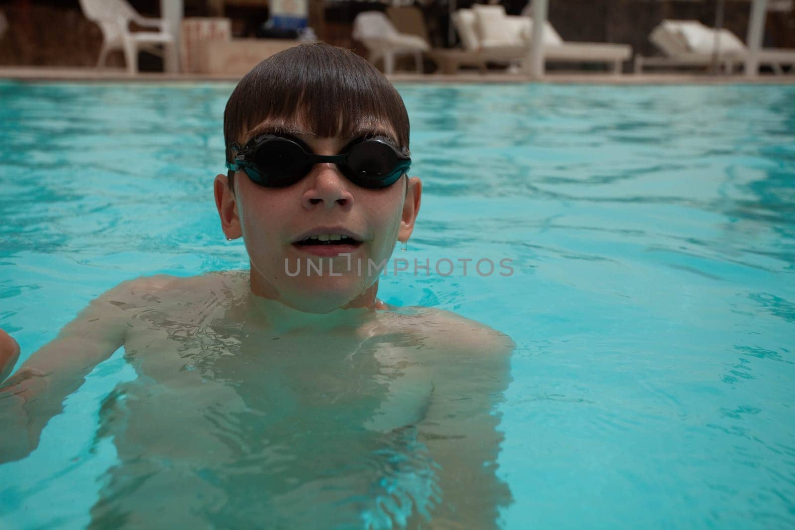 Boy with glasses swims in the pool. High quality photo