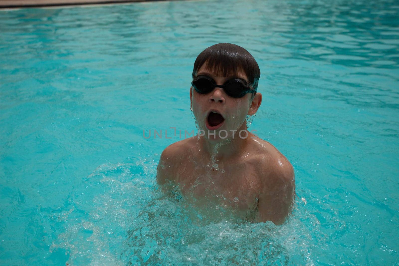 Boy with glasses swims in the pool. High quality photo