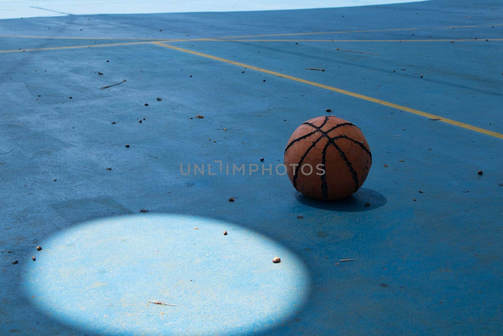 An old basketball ball is sad on the court. High quality photo
