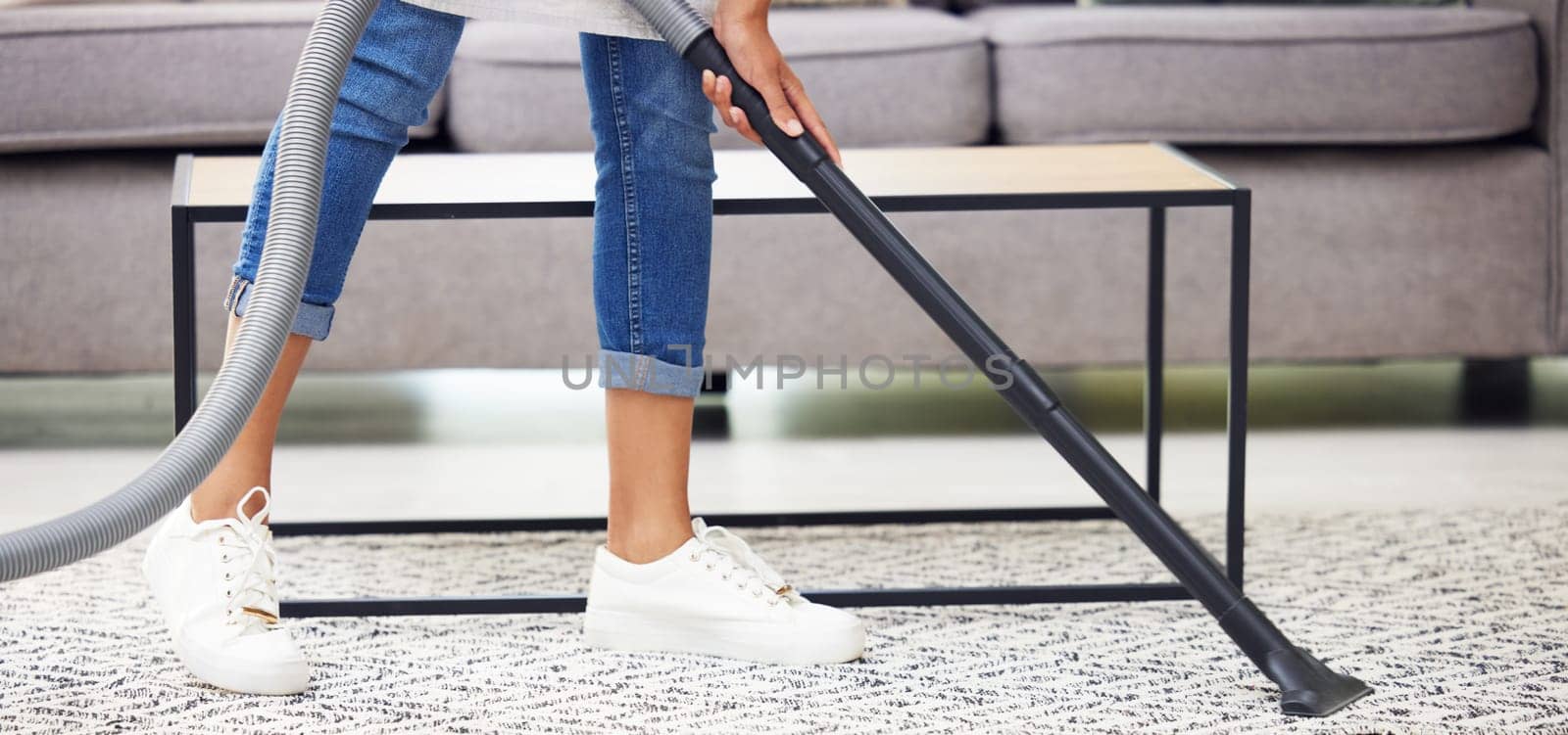 Legs, vacuum and carpet in home, living room and spring cleaning service for dust, bacteria or dirt for health. Person, housework and cleaner with machine for flooring, rug or job at house in Mexico by YuriArcurs