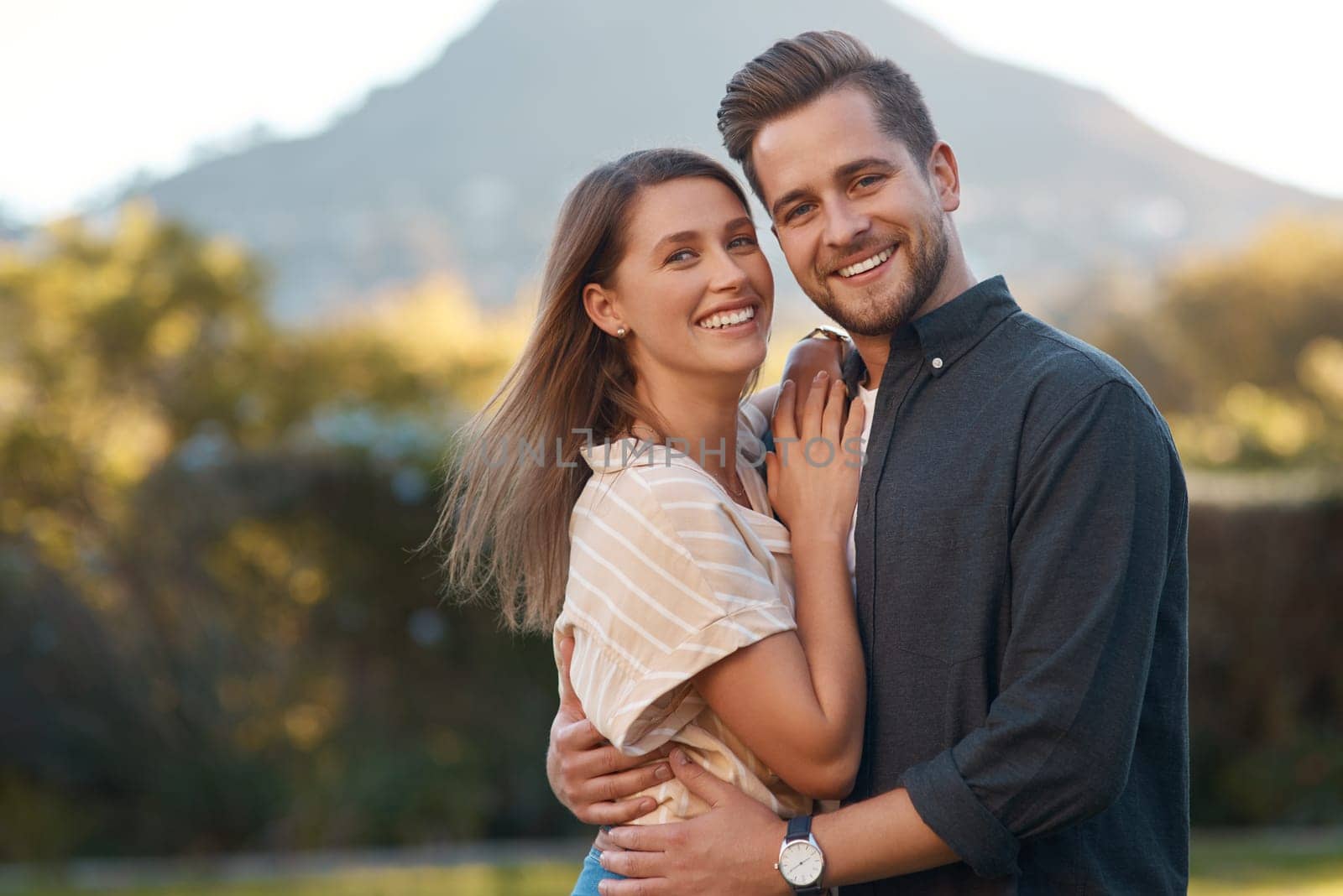 Nature, happy and portrait of couple with hug on outdoor date for love, romance and anniversary. Man, woman and smile in relationship with embracing for bonding together in garden on weekend vacation by YuriArcurs