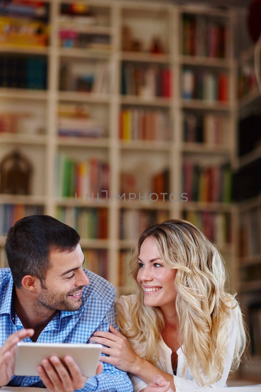 Happy couple, tablet and online in house with smile for future holiday, internet and connection. Smiling man, woman and tech in home with happiness for romantic vacation, search travel and bonding by YuriArcurs