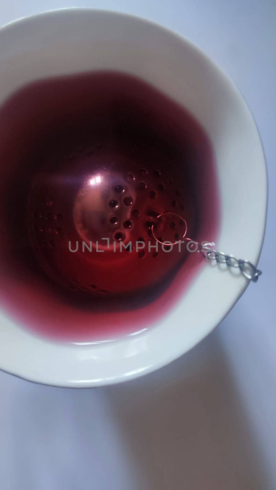 red hibiscus tea in a cup with a strainer, drink. High quality photo