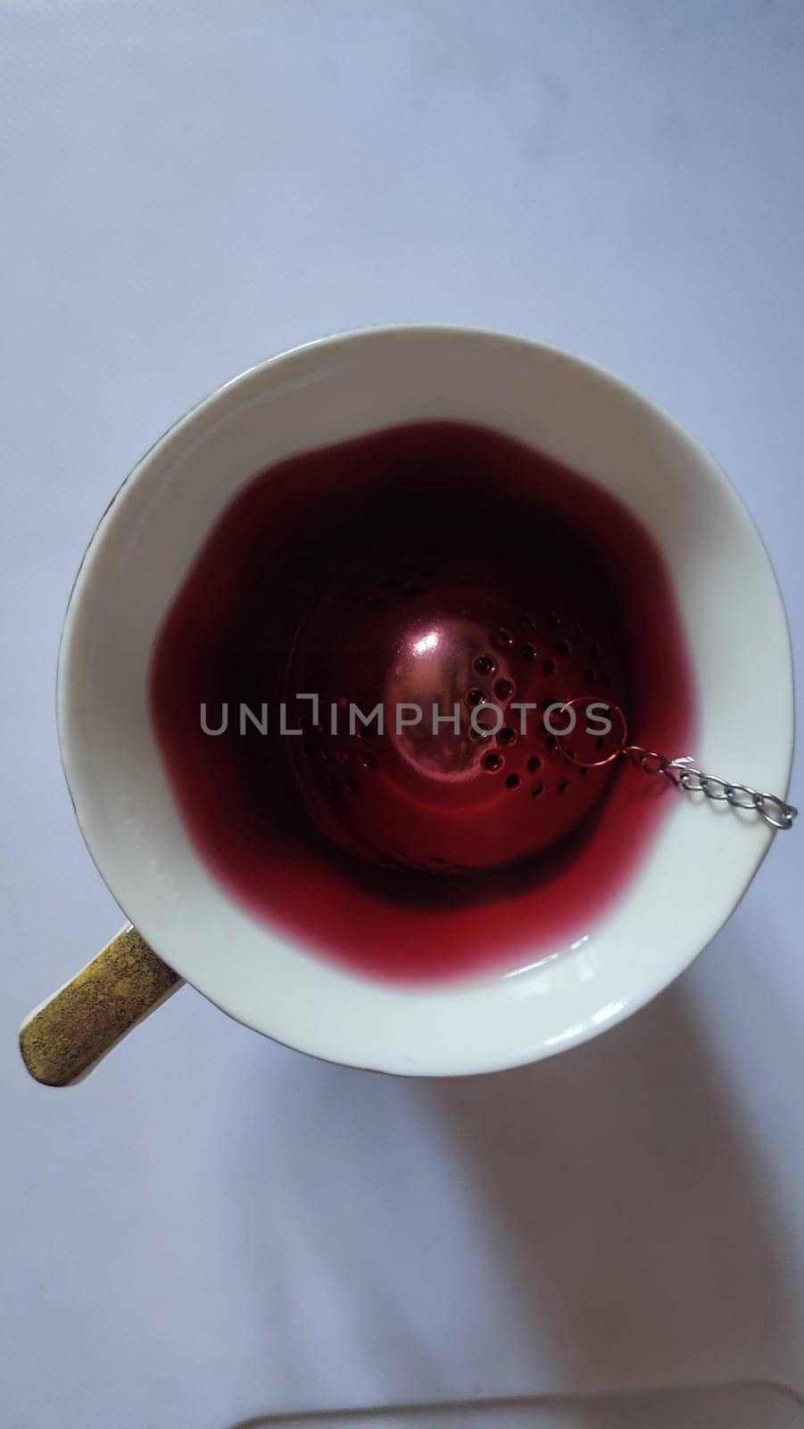 red hibiscus tea in a cup with a strainer, drink. High quality photo