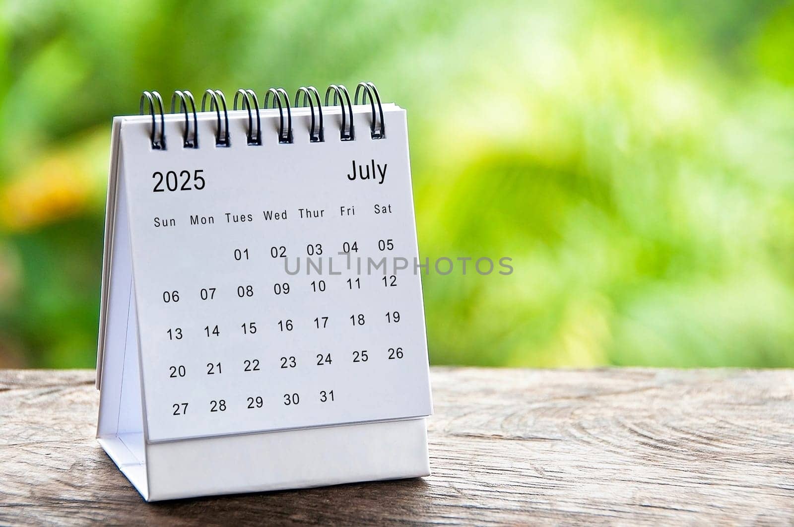 July 2025 white table calendar with customizable space for text. Calendar concept and copy space.