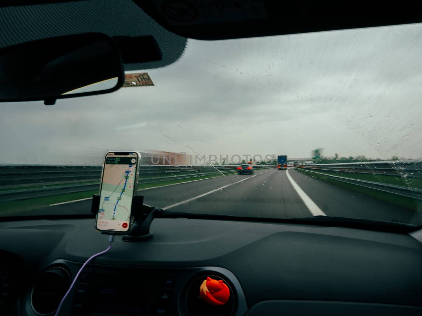 5g Smartphone displaying GPS navigation mounted on a car's dashboard, A1 A8 near Milan, Italy