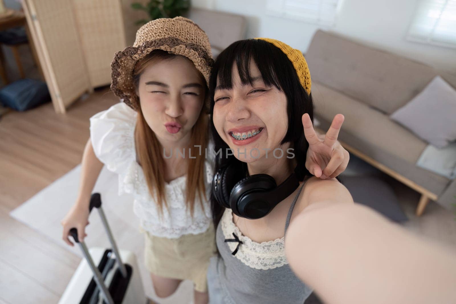 Two Asian woman traveler smile take a photo selfie together. Summer vacation travel concept by nateemee