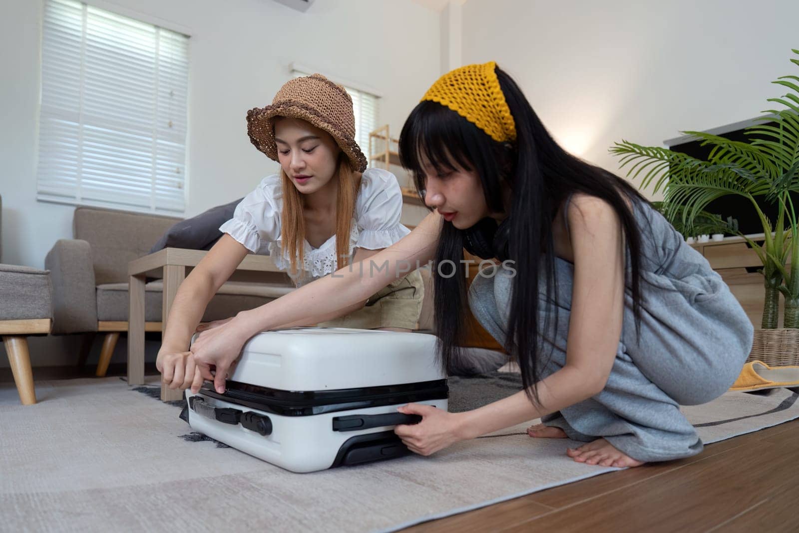 Young woman packing suitcase at home. Travel concept.