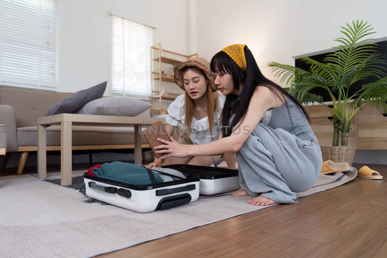 Young woman packing suitcase at home. Travel concept.