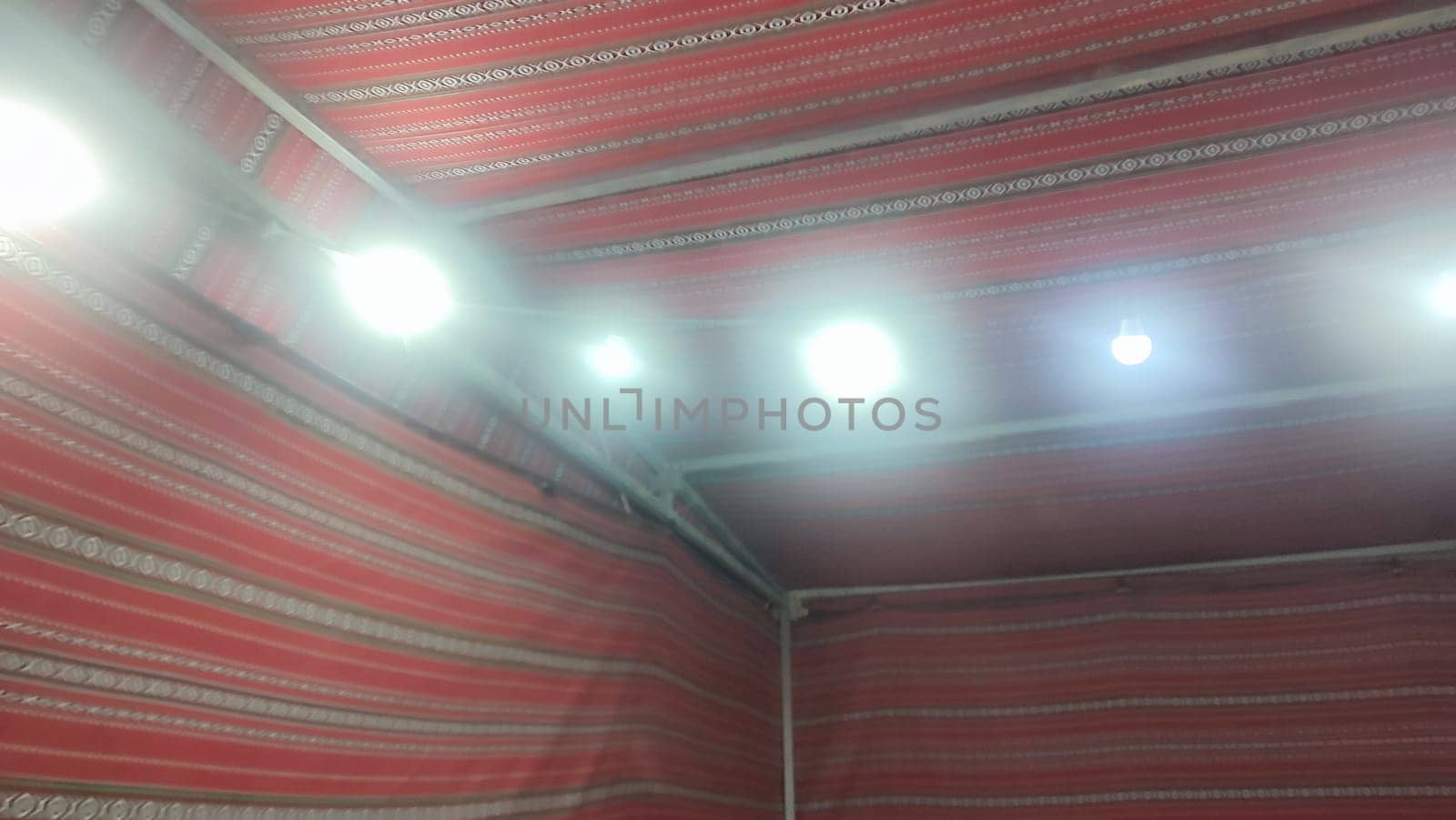 Bedouin tent, red traditional fabric, light bulbs. High quality photo