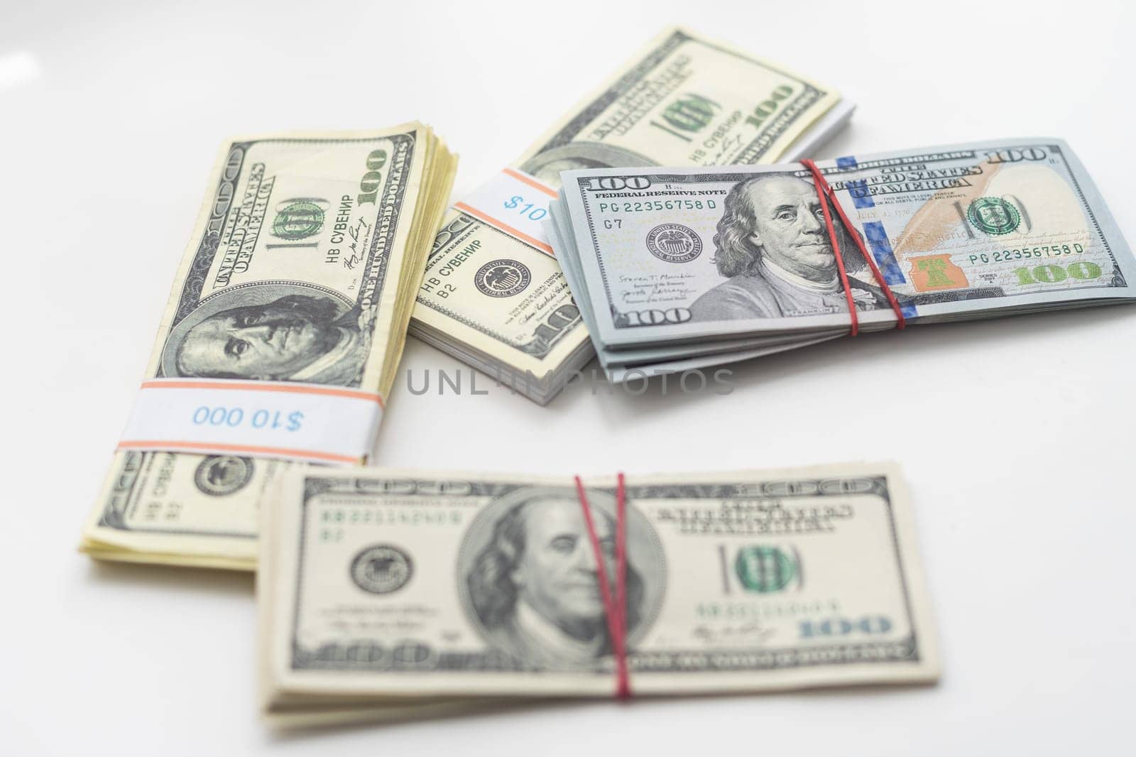 A bankroll of 100 bills on top of a pile of cash. High quality photo