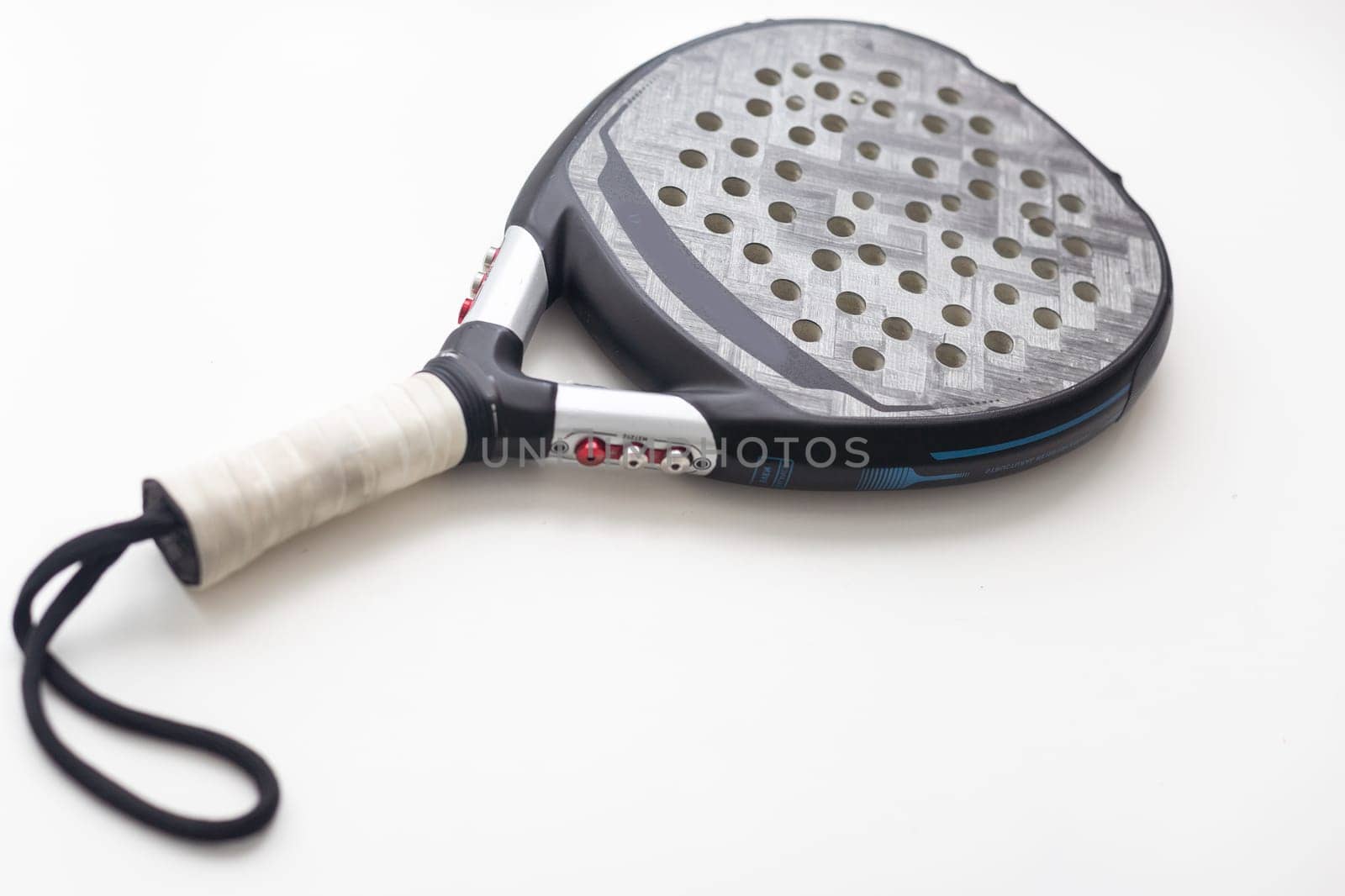 Set of paddle tennis rackets and balls the reflected on white table and white isolated background. Front view. High quality photo