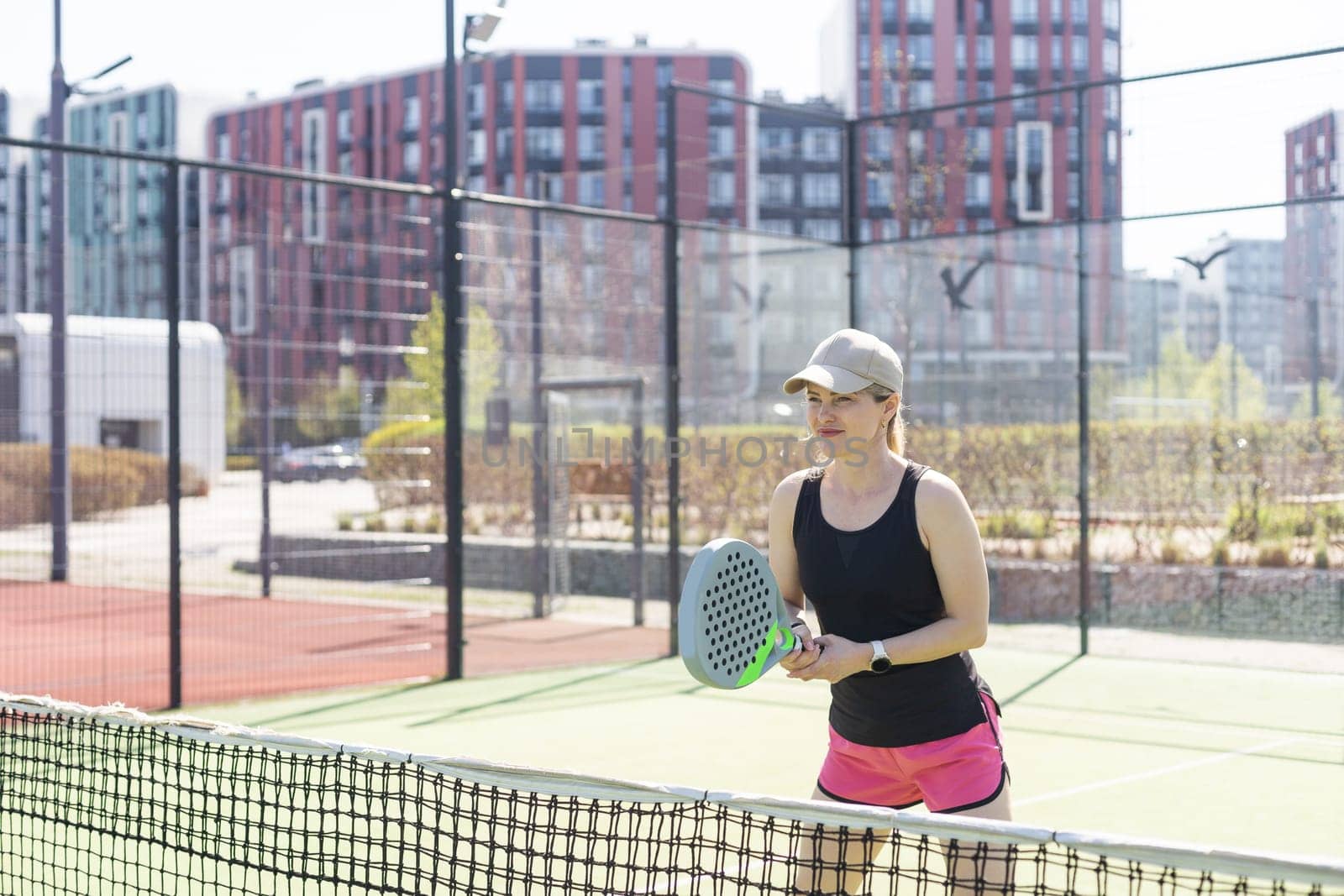 Woman padel tennis player training on court. Woman using racket to hit ball. High quality photo