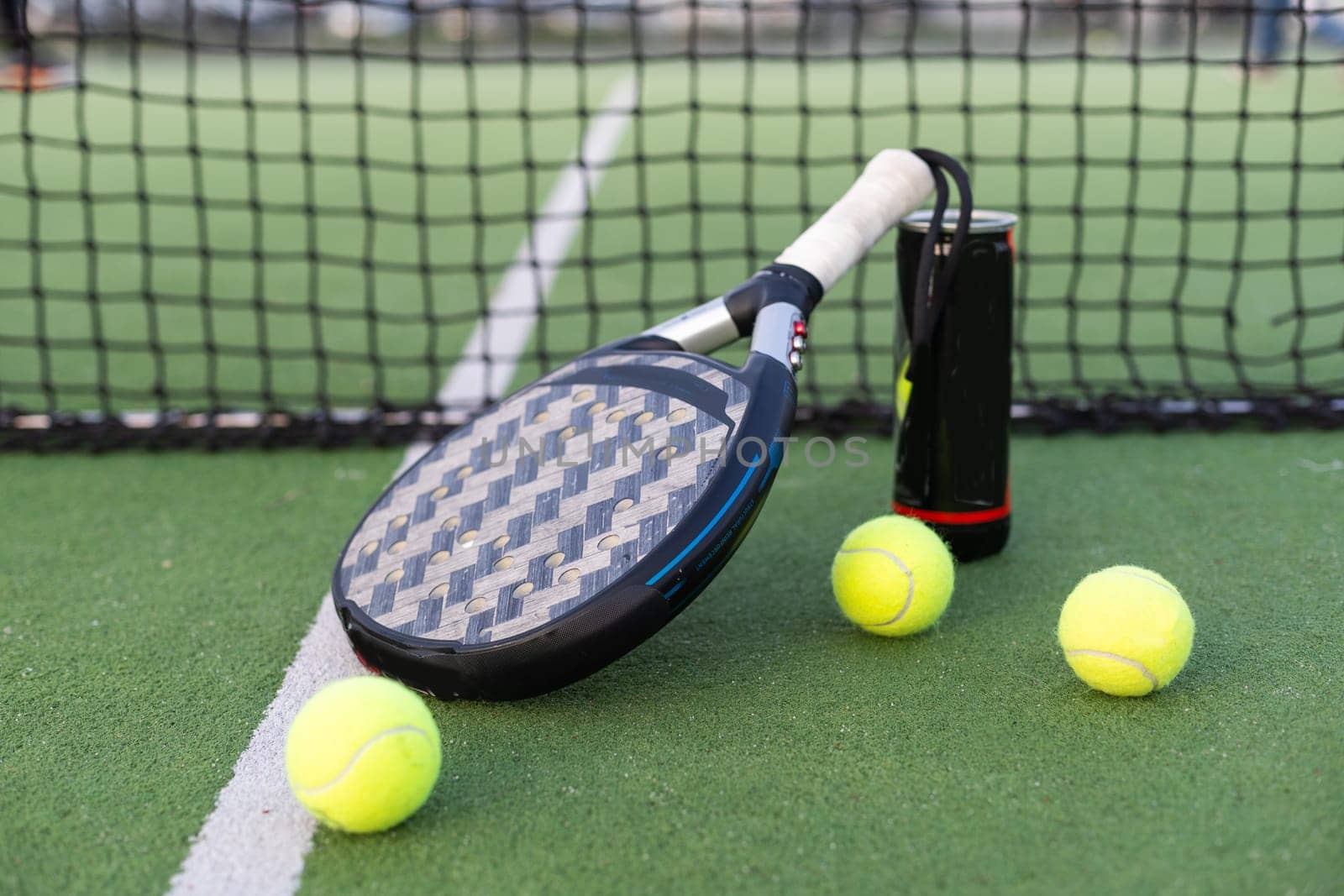 Paddle tennis racket, ball and net on the grass . High quality photo