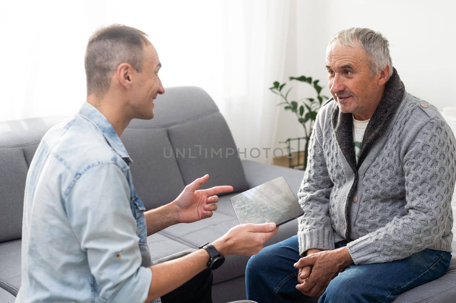 Elderly son takes care of ill father . High quality photo