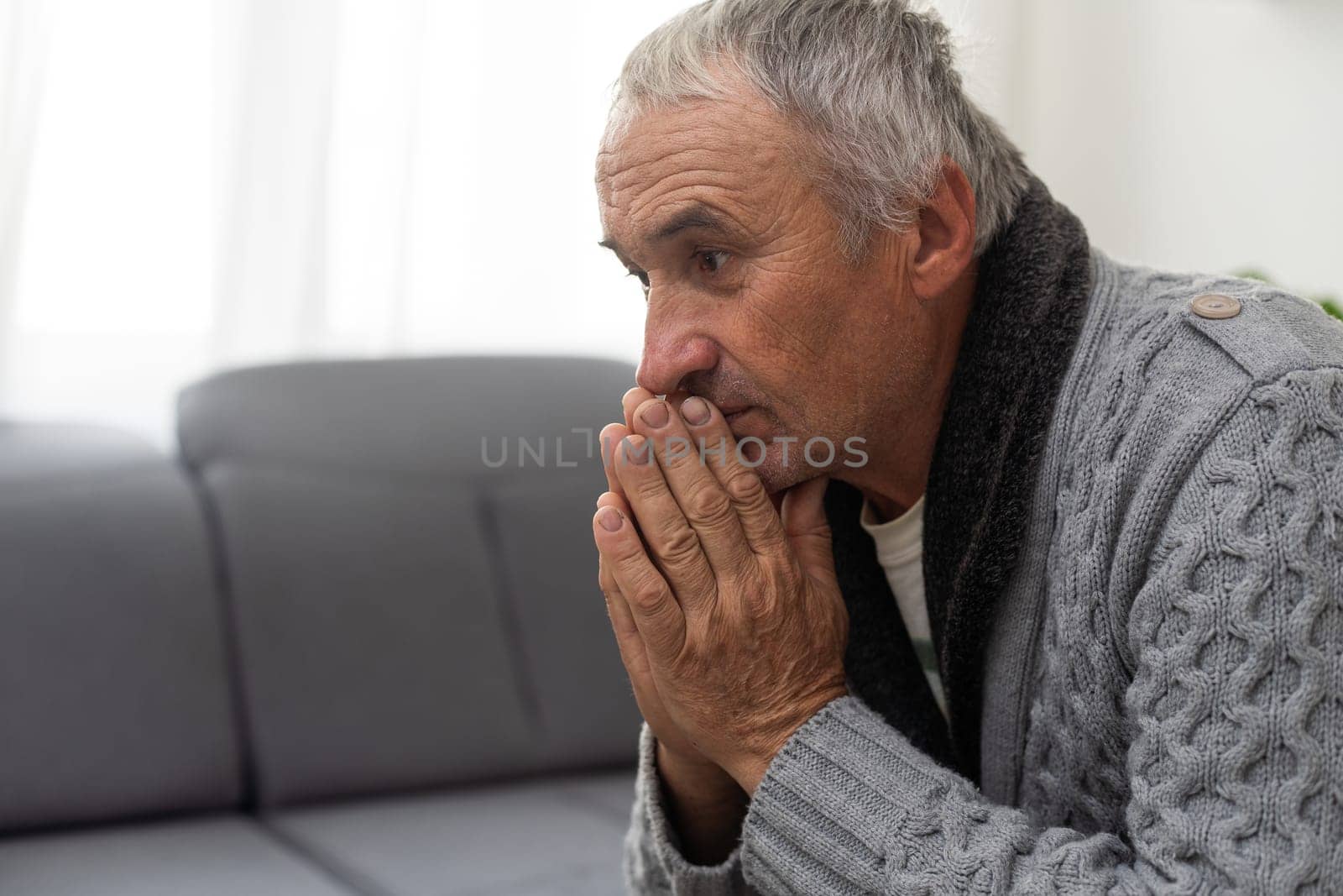 Portrait praying senior man against white background. High quality photo