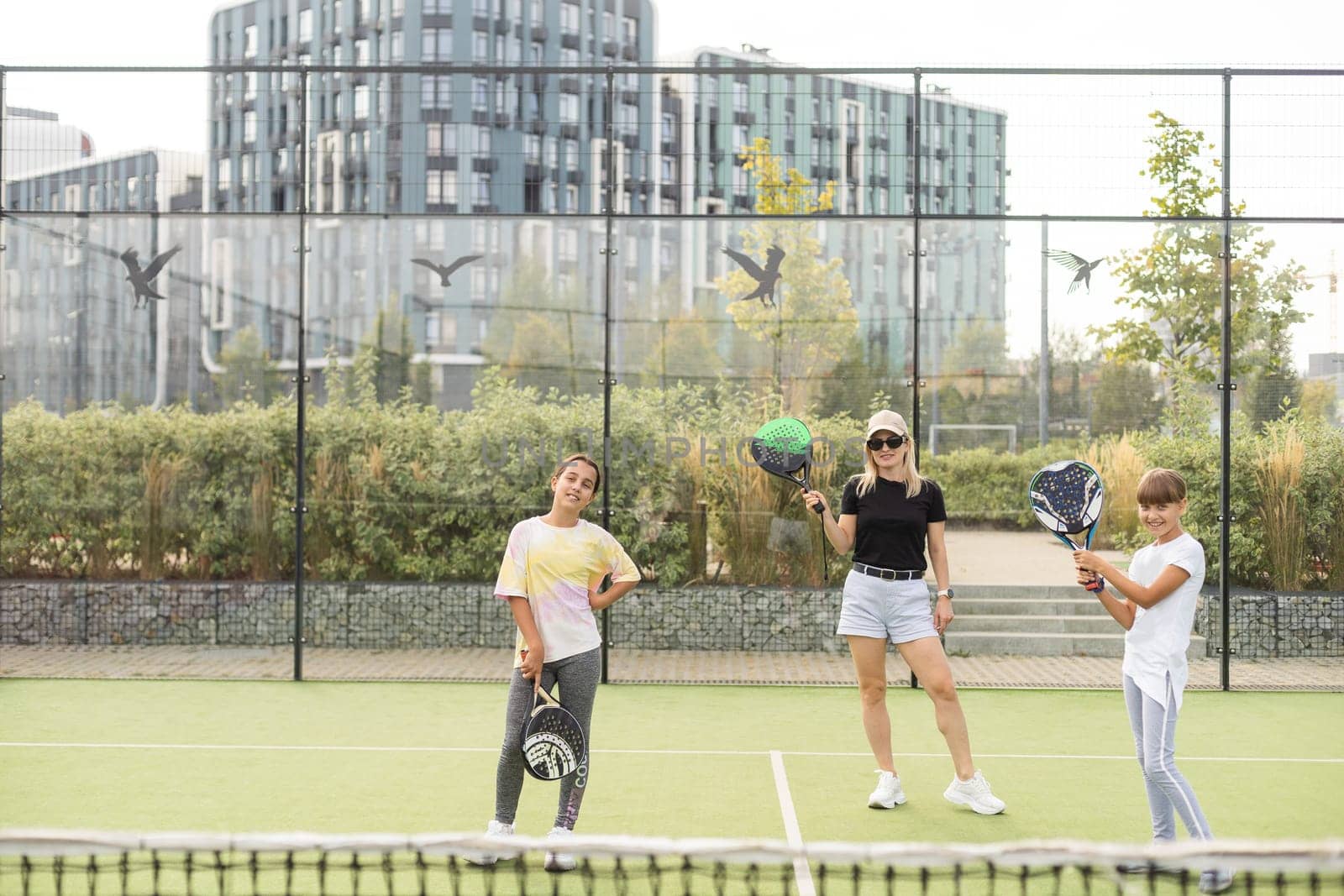 mother and daughters playing padel outdoor. High quality photo