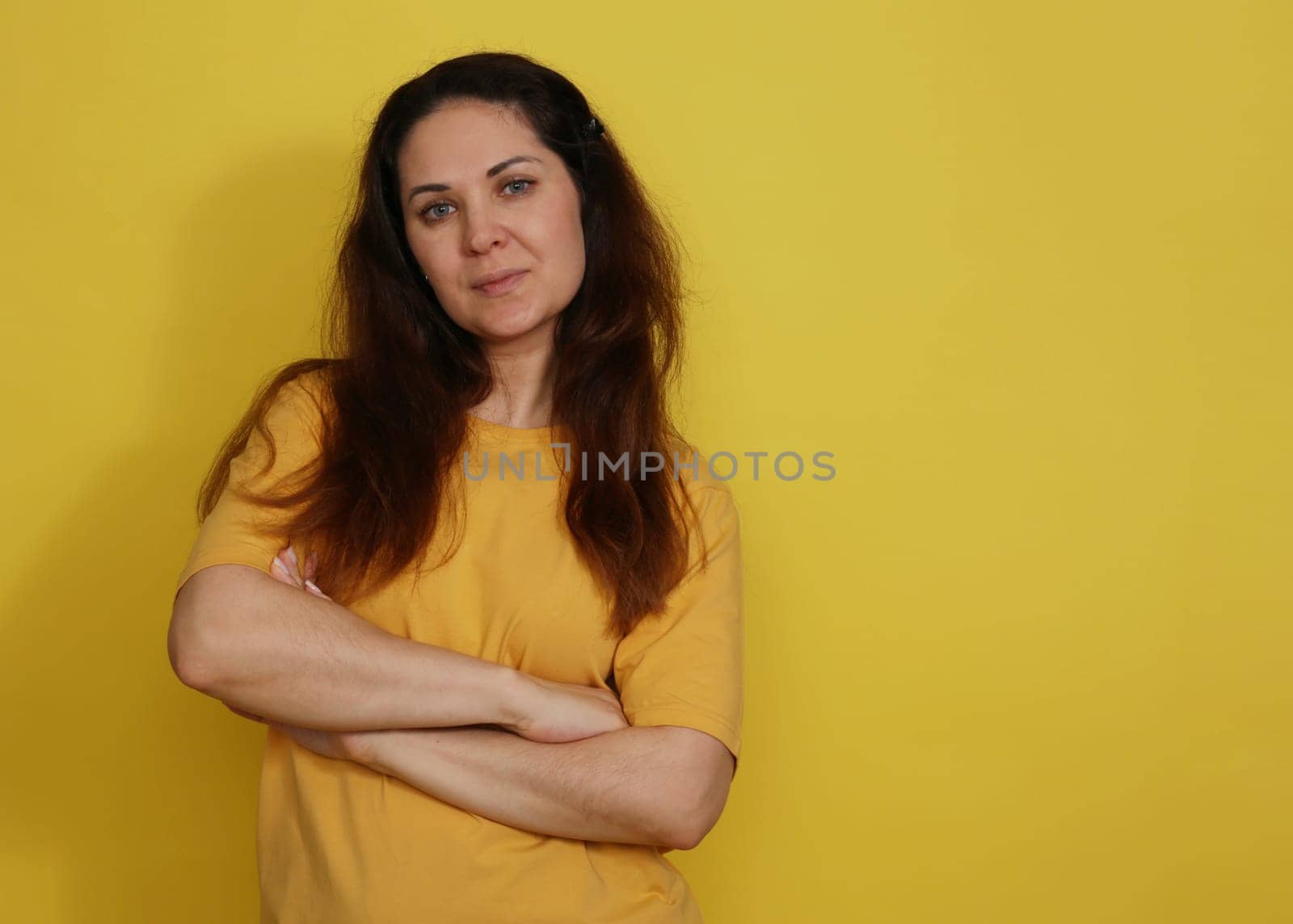 Portrait of an attractive woman in a yellow T-shirt on a studio background. by gelog67