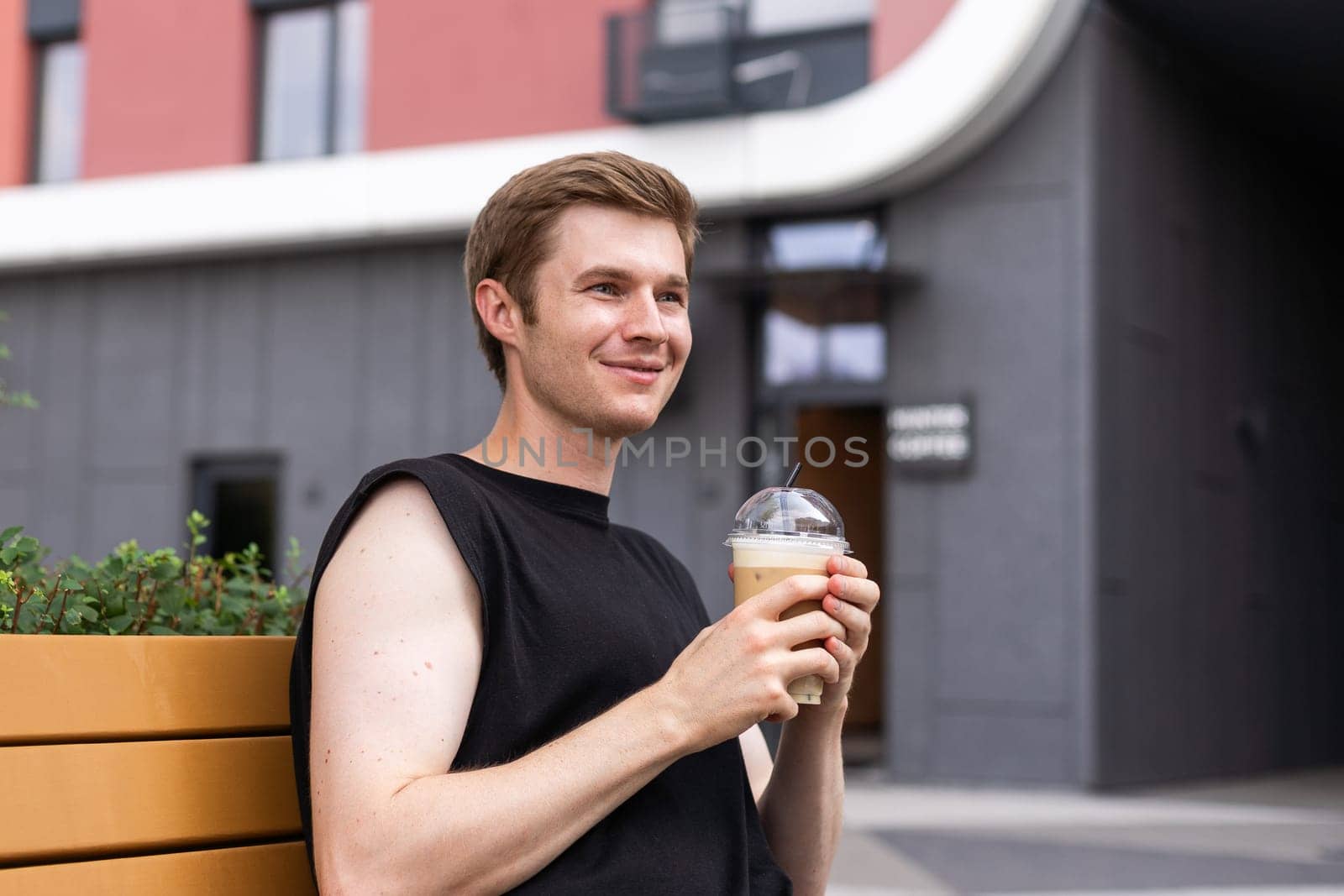 Portrait of good looking young man drinking iced coffee, milk tea or cold chocolate.
