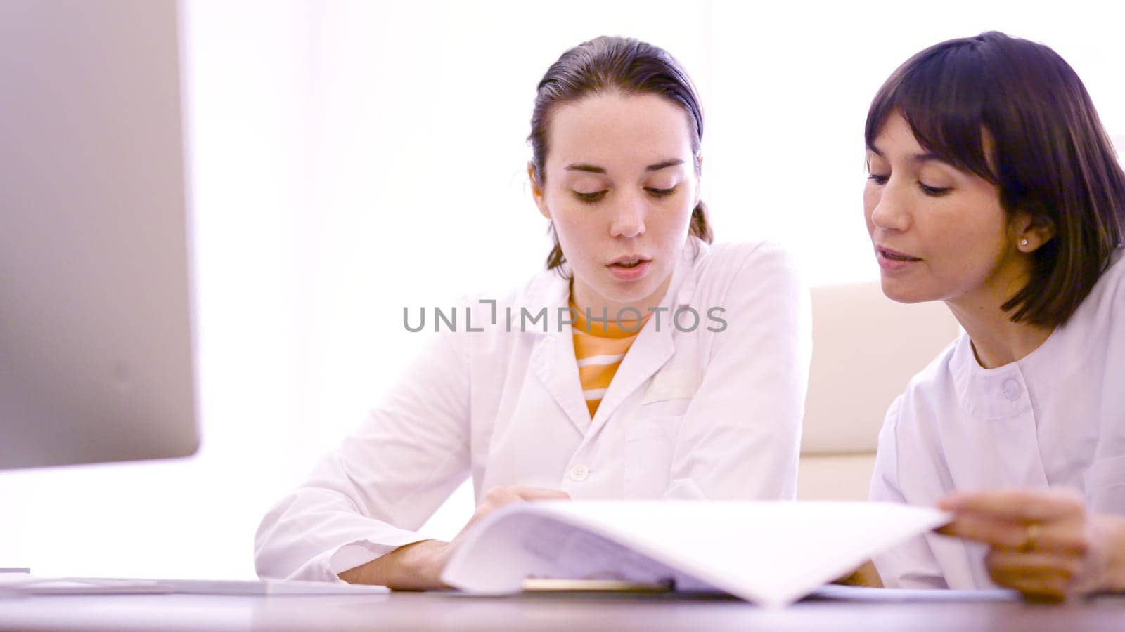 Two doctor consulting a medical inform in the clinic by ivanmoreno