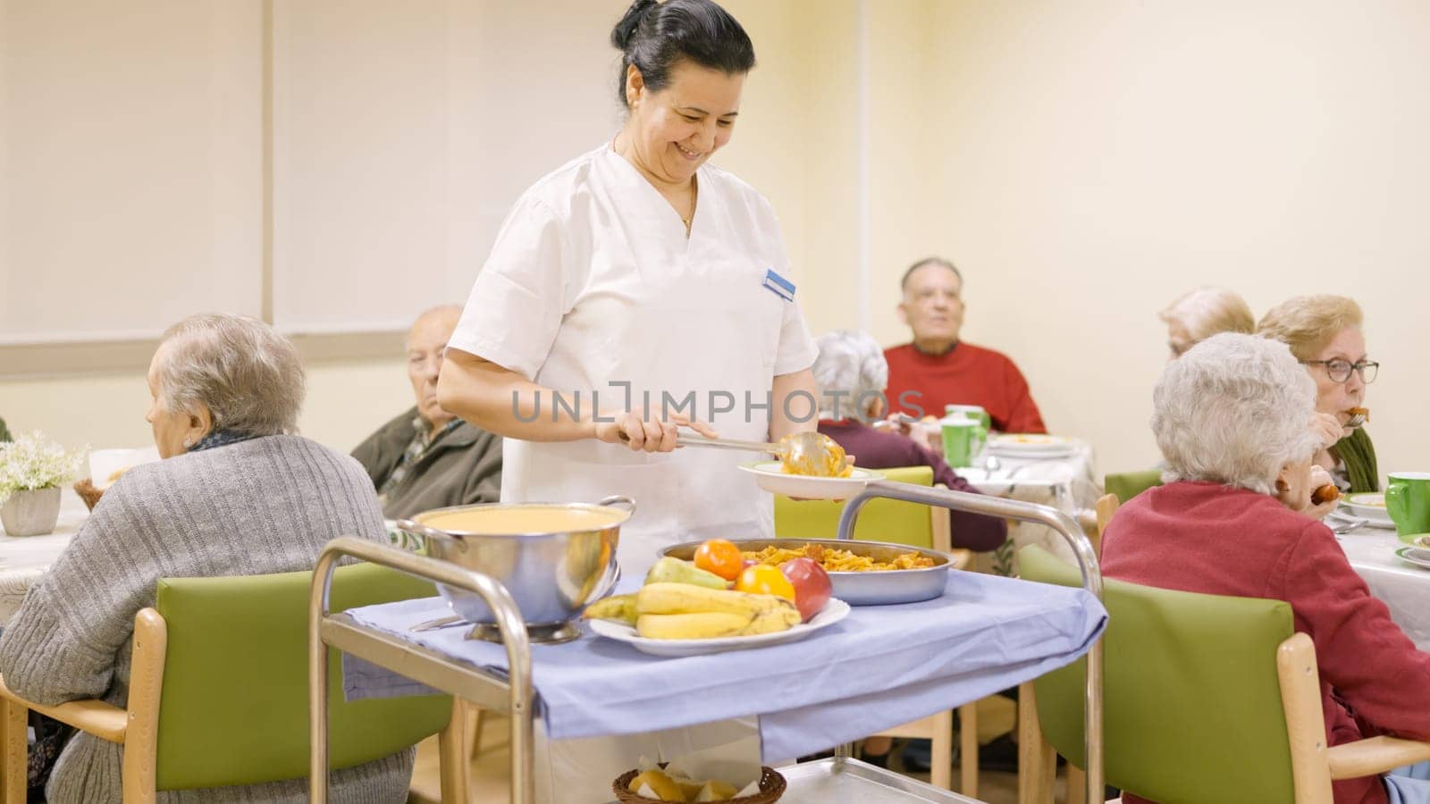 Friendly cook serving food to seniors in a nursing home