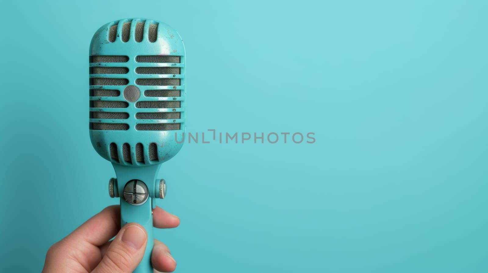 A person holding a blue microphone in their hand