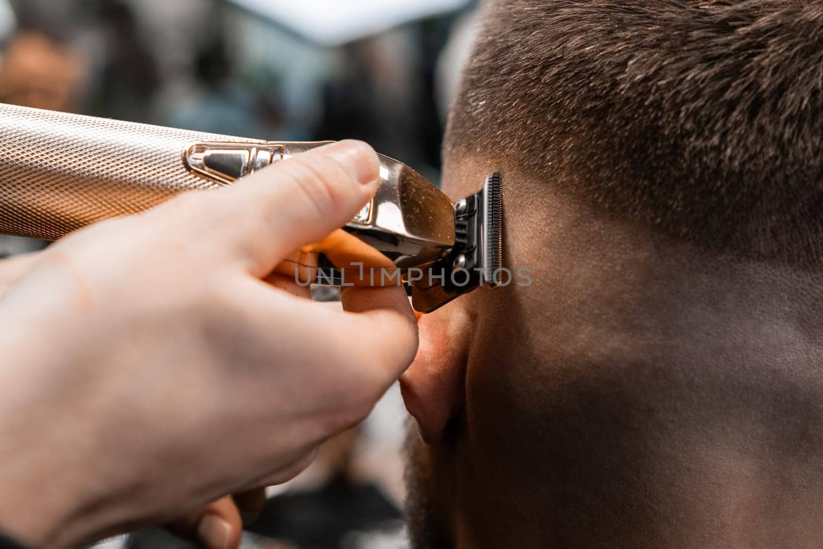 Coiffeur shaves client hair with trimmer in barbershop by vladimka