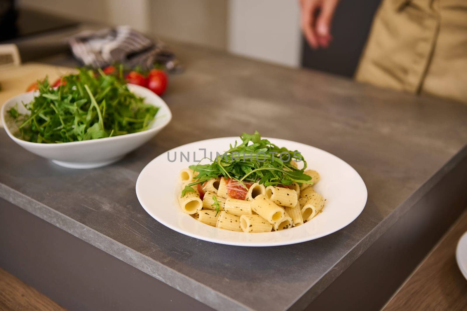 Fresh Italian pasta with green arugula leaves on kitchen table