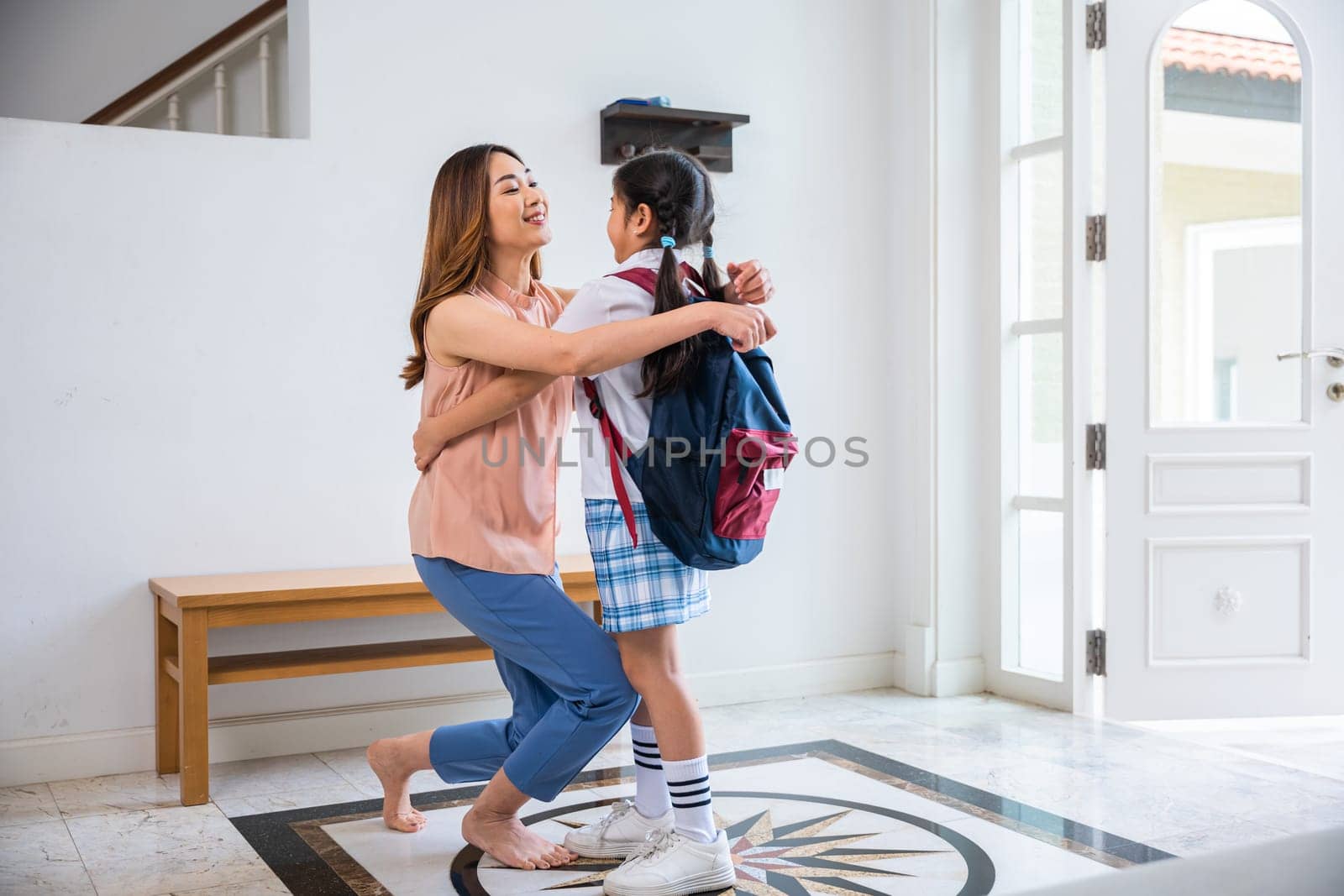 Family mother and schoolgirl with backpack before first day by Sorapop
