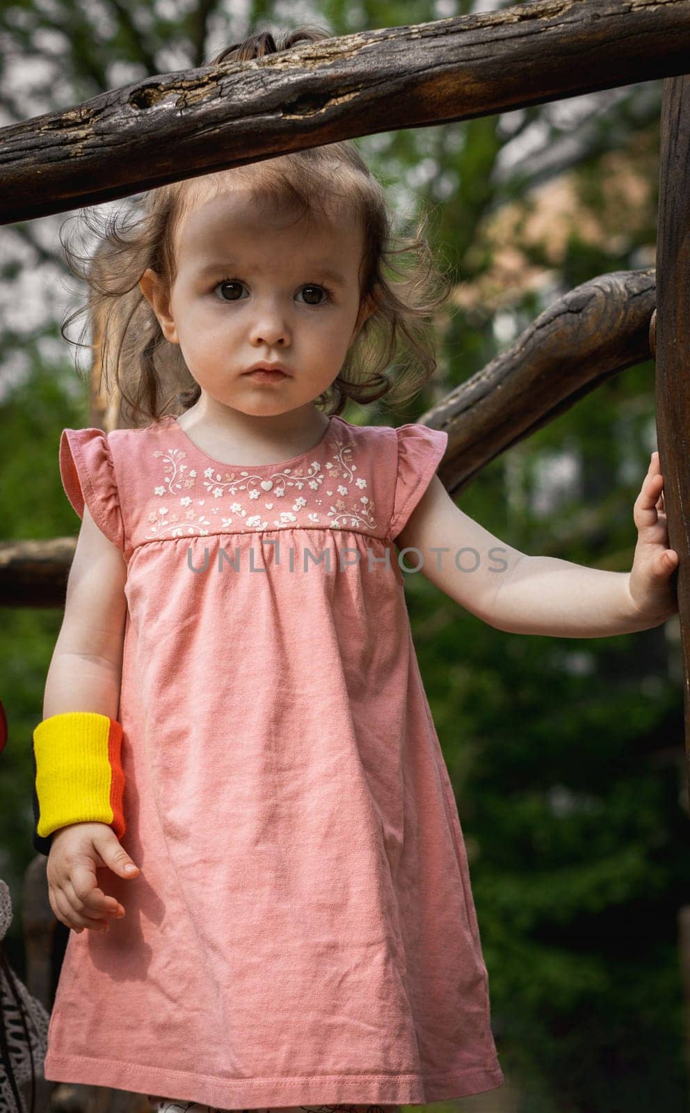 Portrait of a baby girl on the playground in the park. by Nataliya