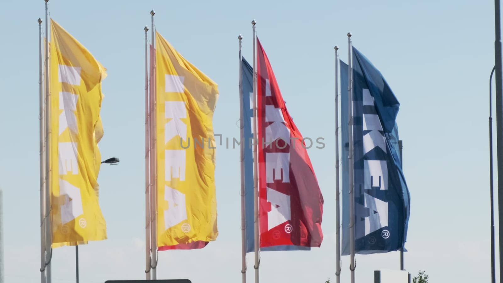 IKEA logo flags in the wind against sky, by vladimka