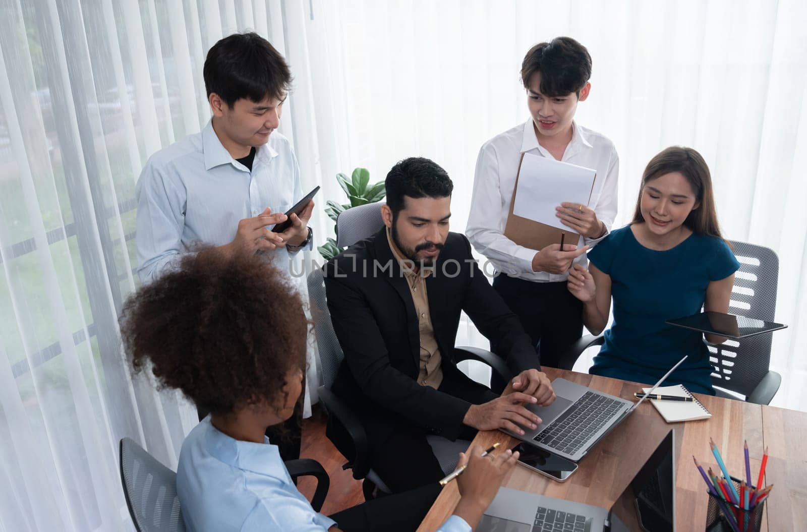 Happy diverse business people work together, discussing in corporate office. Professional and diversity teamwork discuss business plan on desk with laptop. Modern multicultural office worker. Concord