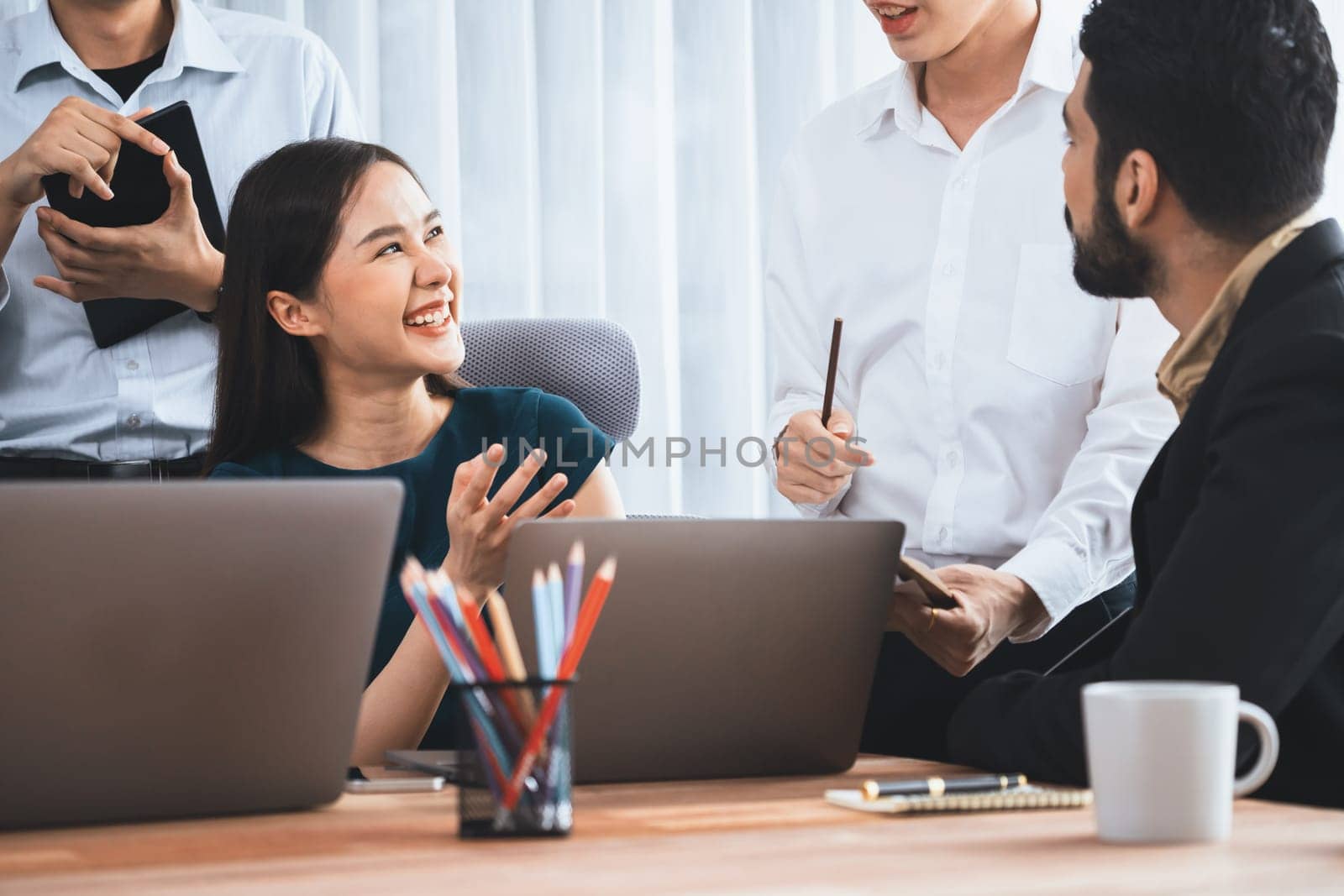 Professional Asian employee work together as team in corporate office, discussing business plans and data to achieve success on desk with laptop. Modern office worker teamwork concept. Concord