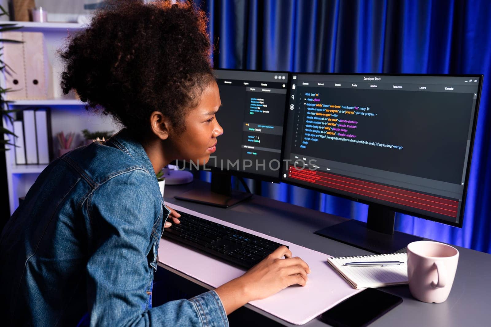 Young African IT professional developer wearing jeans shirt cheeking cyber code, concentrate on laptop screen, display data of application and website, create innovative updated version. Tastemaker.