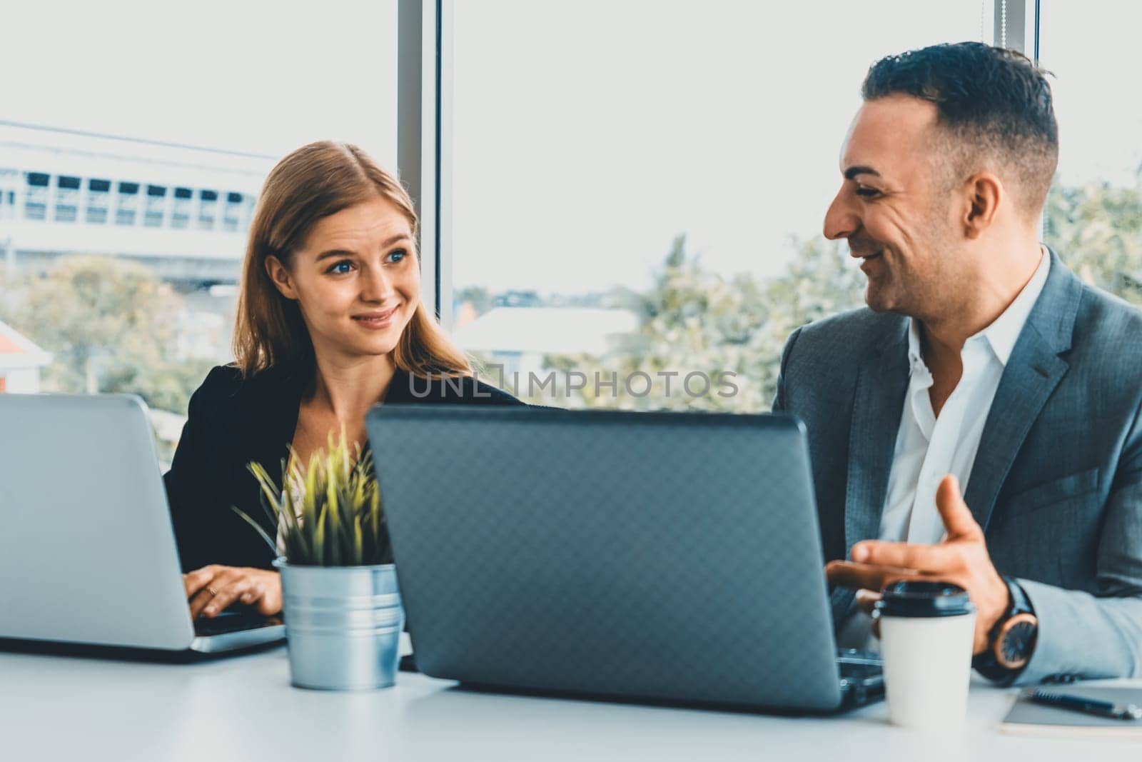 Businessman executive is in meeting discussion with a businesswoman worker in modern workplace office. People corporate business team concept. uds