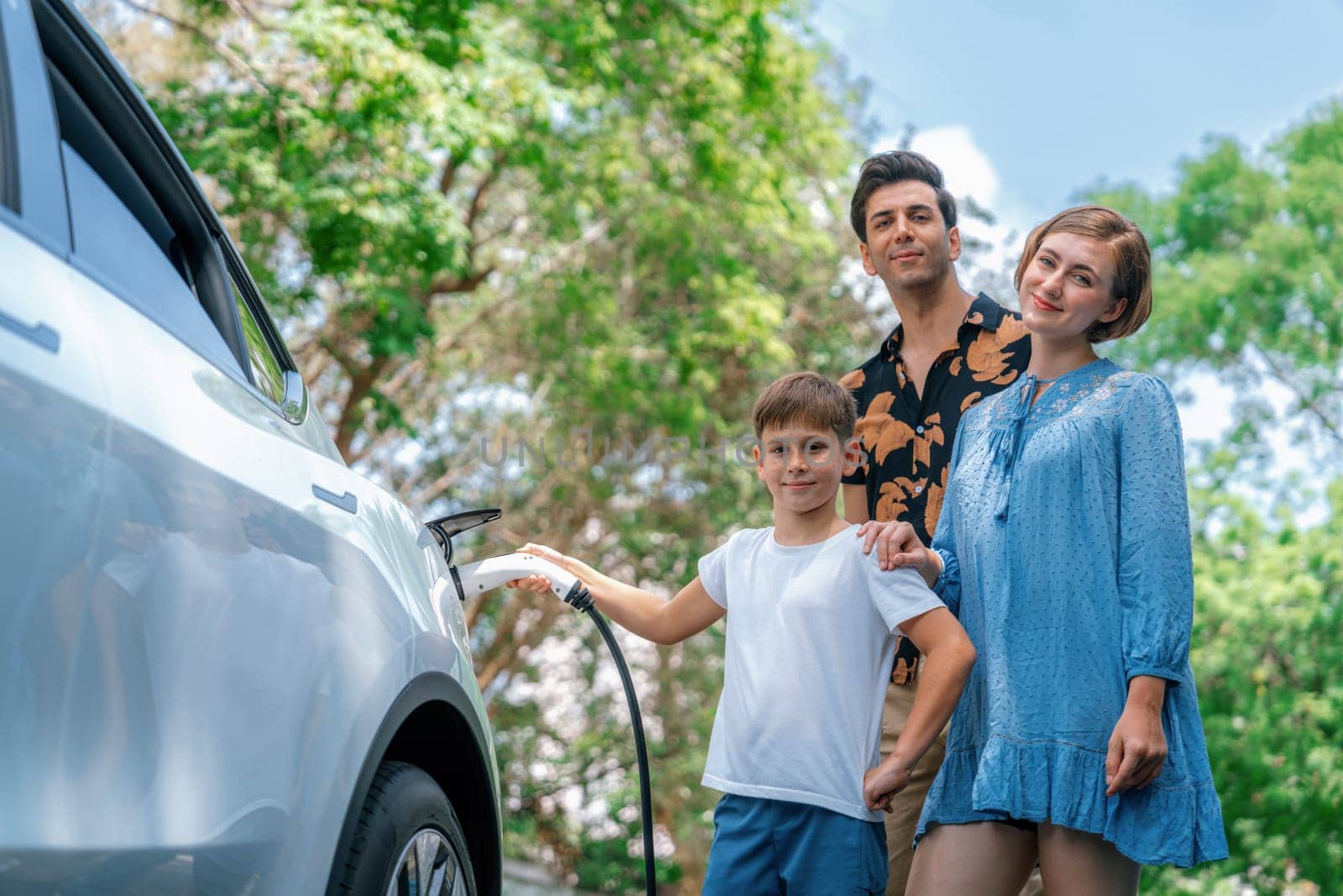 Family road trip vacation with electric vehicle, lovely family recharge EV car with green and clean energy. Natural and eco friendly car travel for sustainable environment. Perpetual