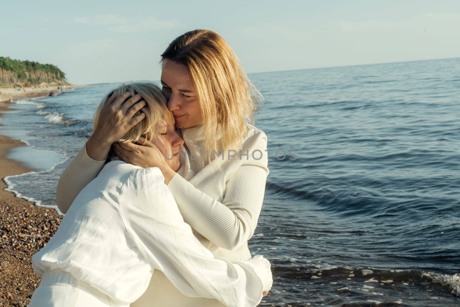 Mom hugs her daughter on the beach by the sea. by Sd28DimoN_1976