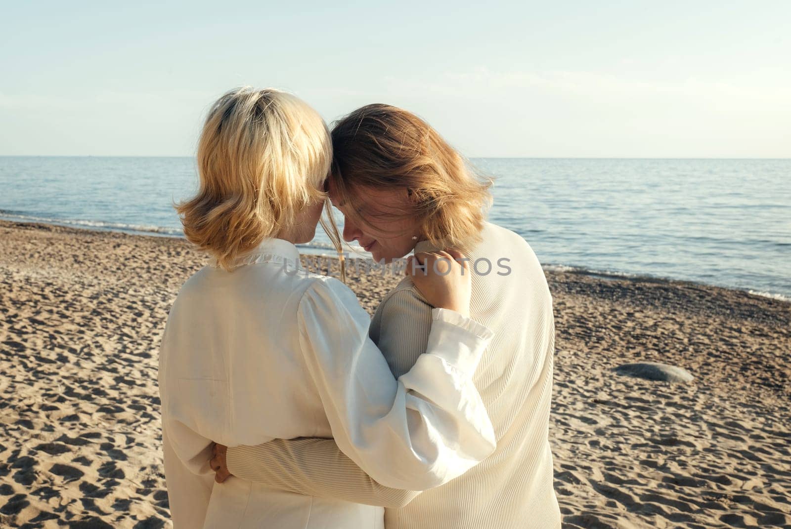 Mom and daughter are standing on the beach by the sea, hugging by Sd28DimoN_1976