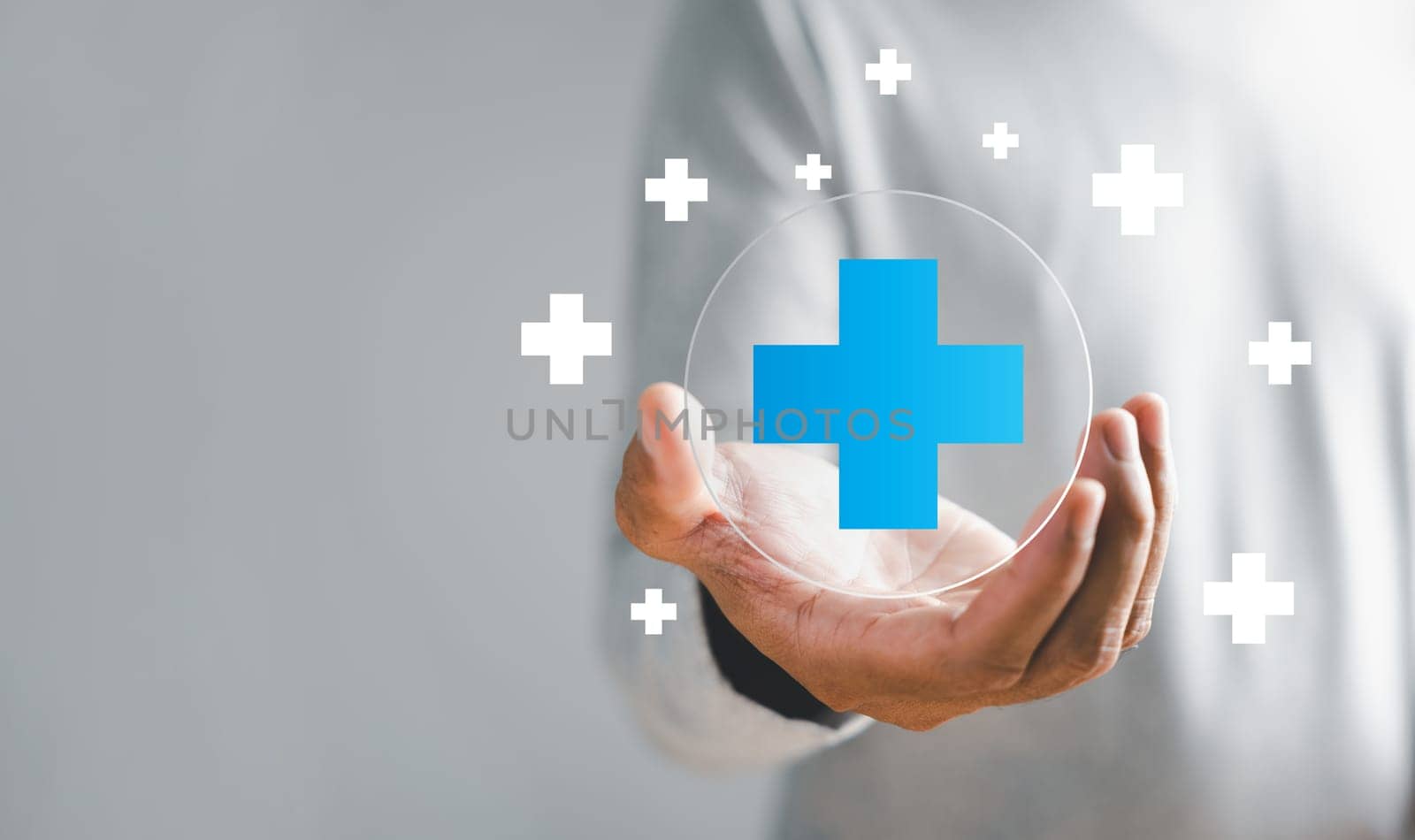 A hand grasps plus icon for medical care, signifying advantages. Health insurance health concept featuring access to welfare health and unoccupied space.