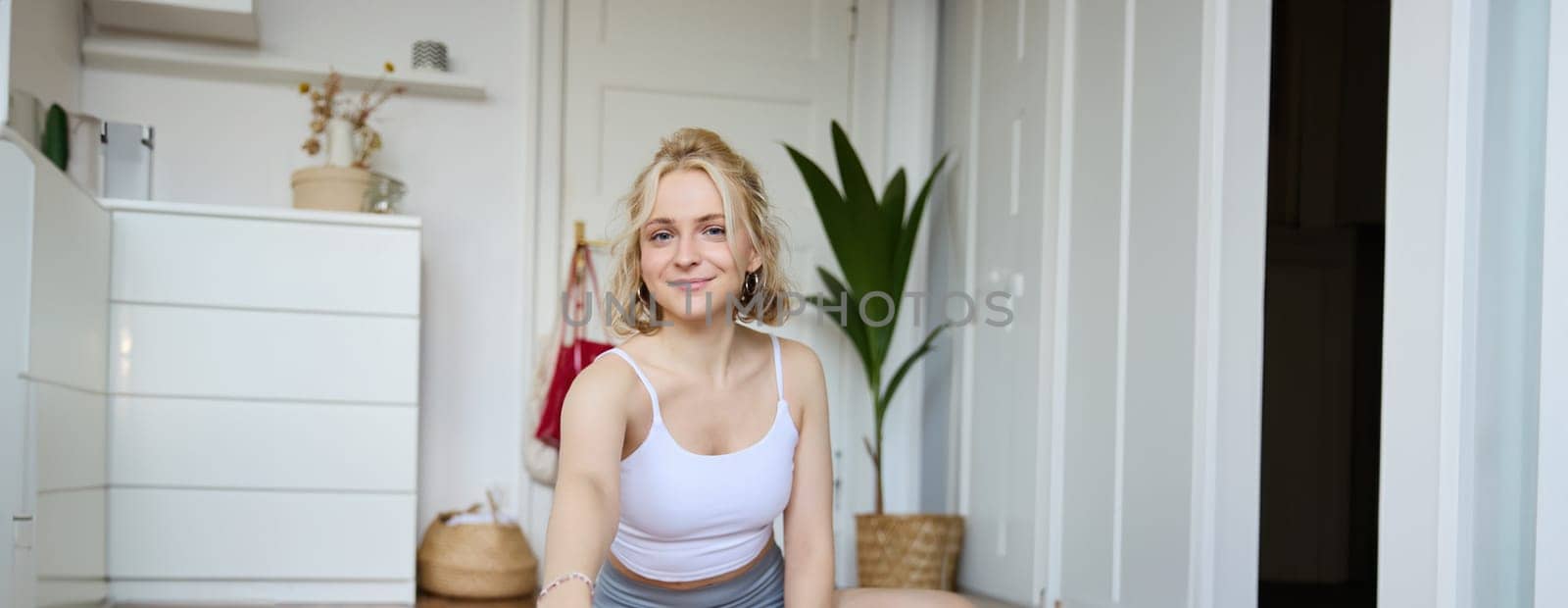 Vertical shot of woman sitting on yoga mat, recording video on digital camera, vlogging about workout at home and fitness lifestyle, showing how to stay fit and healthy indoors by Benzoix