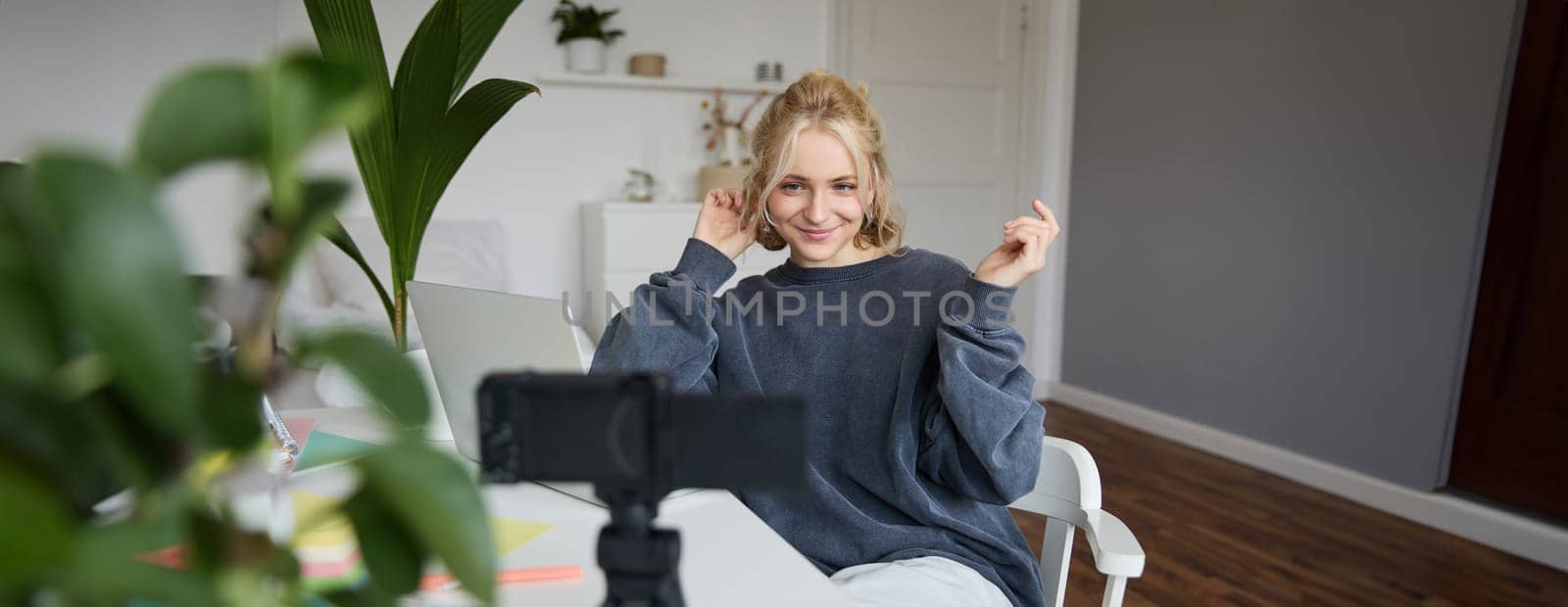 Portrait of young woman, lifestyle blogger, recording vlog video about her life and daily routine, sitting in front of laptop, talking to followers, sitting in her room.