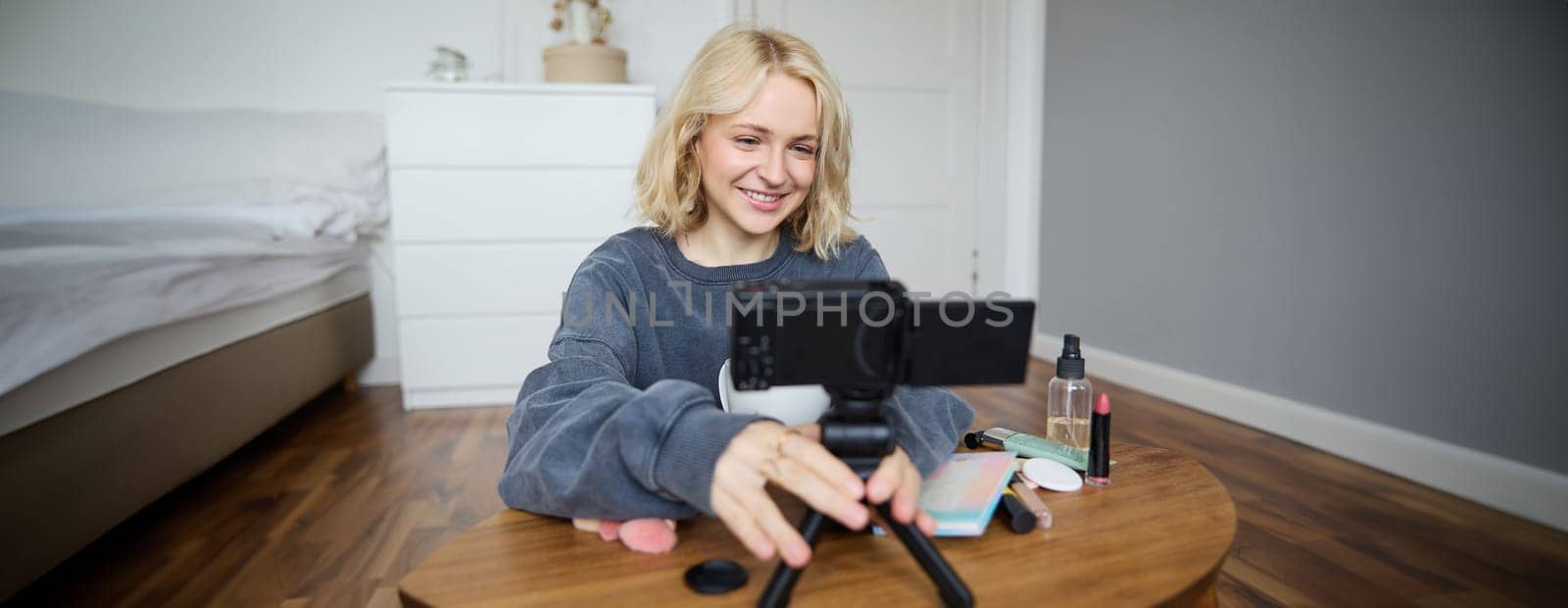 Portrait of young teenage girl in her room, recording a vlog, daily lifestyle video for social media, internet influencer advertising product online, talking to the camera, sitting on the floor by Benzoix