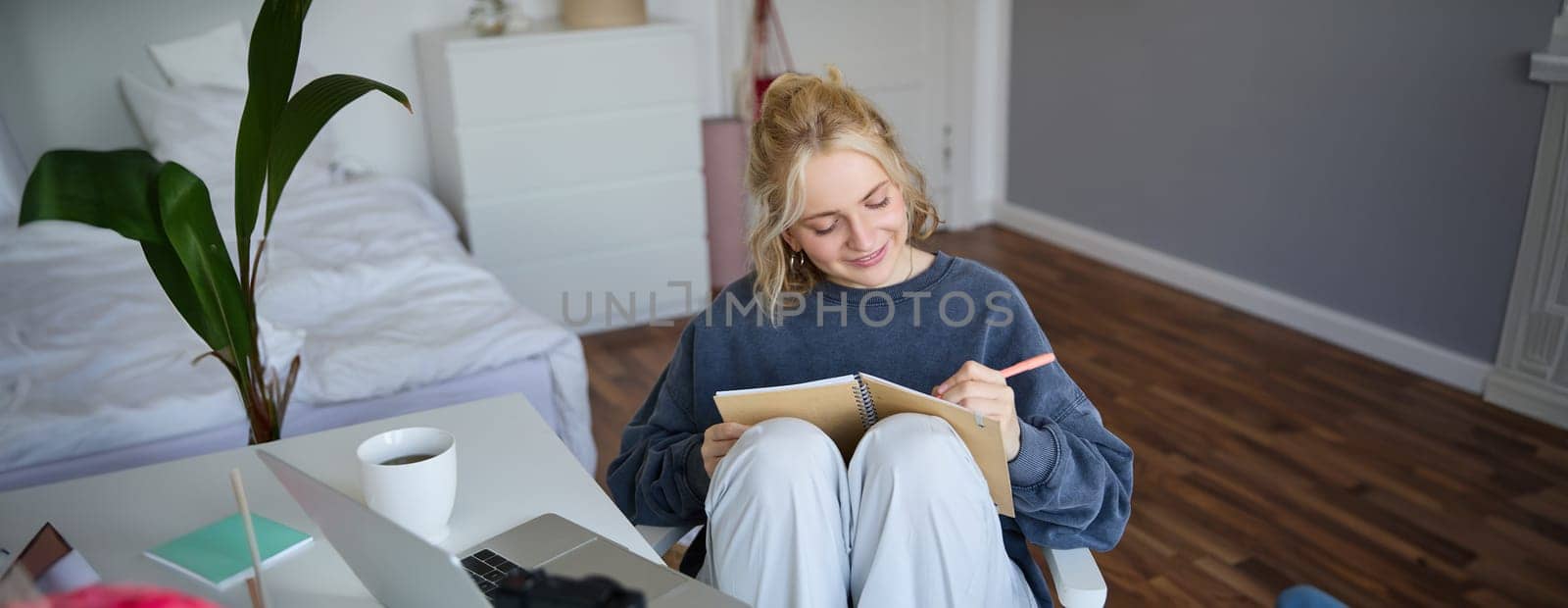 Portrait of cute, smiling young social media content creator, girl records video on digital camera and stabiliser, holds notebook, talks to audience, vlogging in her room by Benzoix